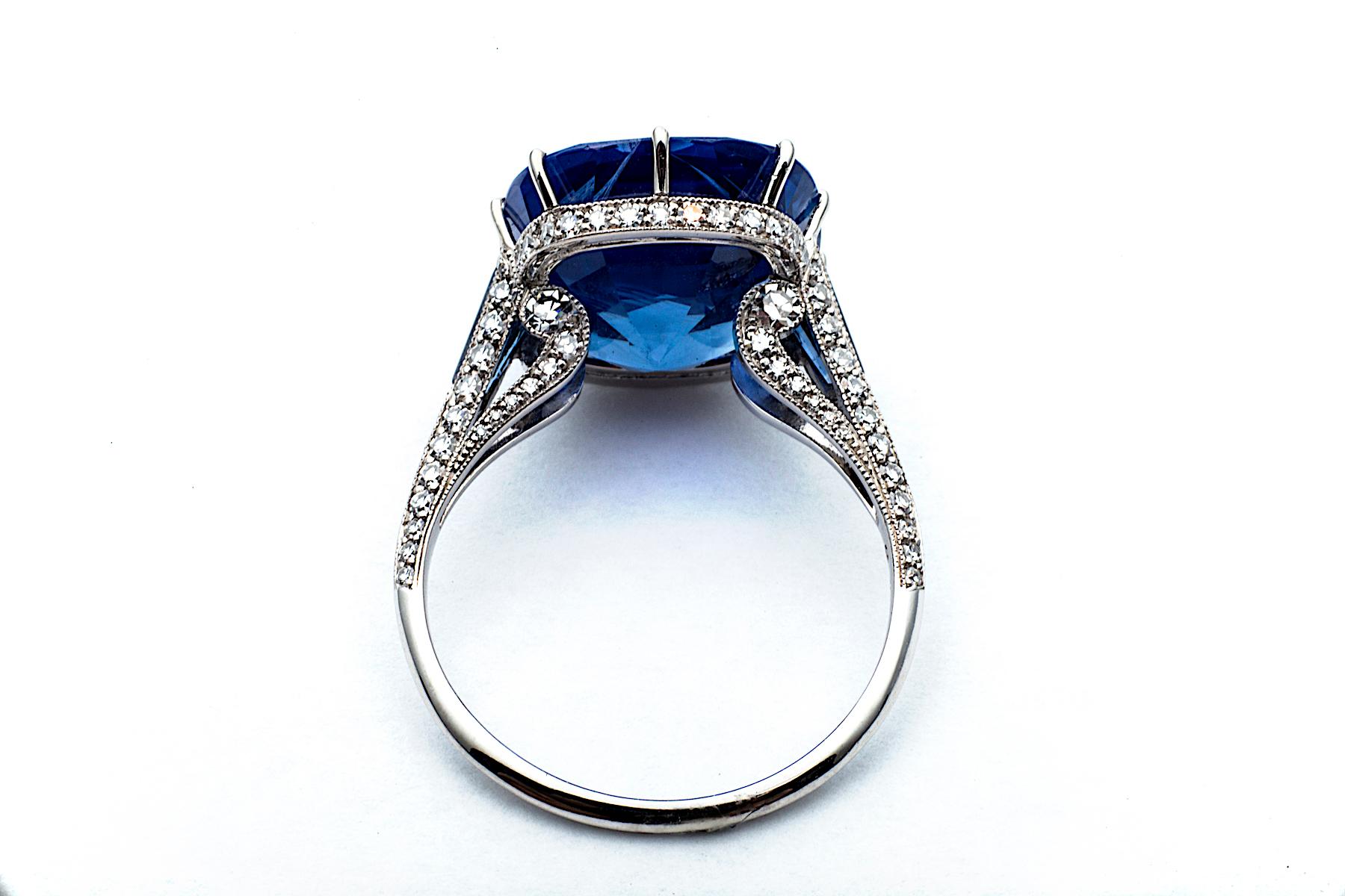 With a regal deep velvet blue color, this extraordinary vivid sapphire is fit for a Queen.  The one-of-a-kind 9.33 carat antique cushion cut natural sapphire is set in a diamond platinum crown shaped handmade basket, with ten delicate prongs, making
