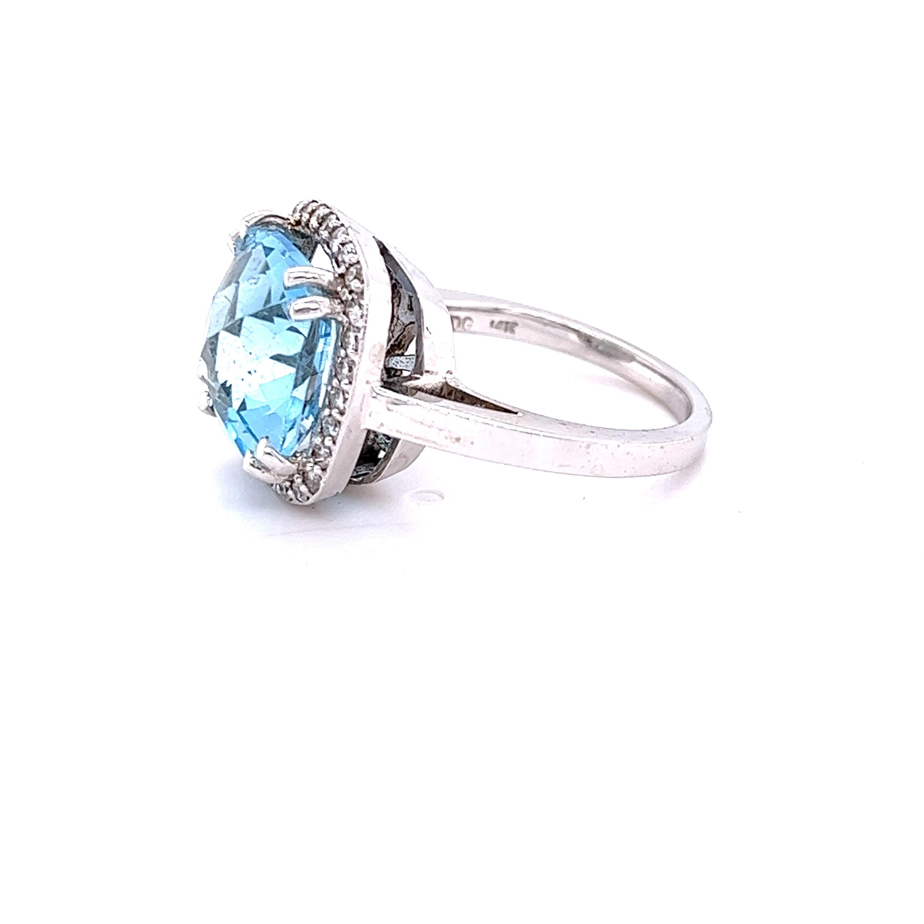 This statement ring has a Cushion Cut Blue Topaz that weighs 8.94 Carats. 
It is surrounded by a simple halo of 28 Round Cut Diamonds that weighs 0.39 Carats. The clarity and color of the diamonds are SI-F. 

It is crafted in 14 Karat White Gold and