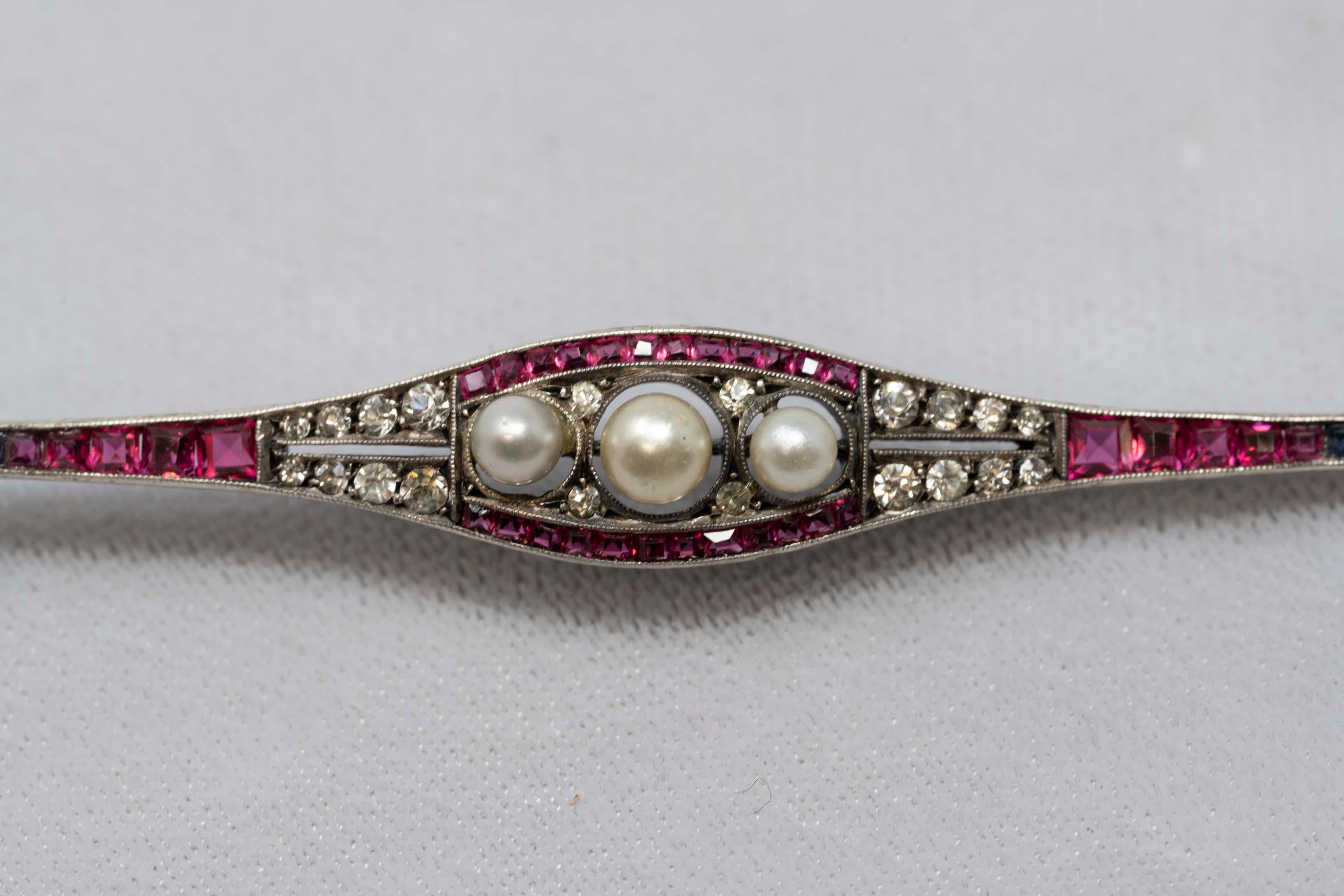 Rare W.B. Wilhelm Becker Germany art deco 935 silver brooch with faux pearls, rubies and diamante paste. Measures 3 1/2 inches long, stamped inside 935 W.B. sterling, rhodium plated, round cut and square stone. Circa 1920, Germany.
