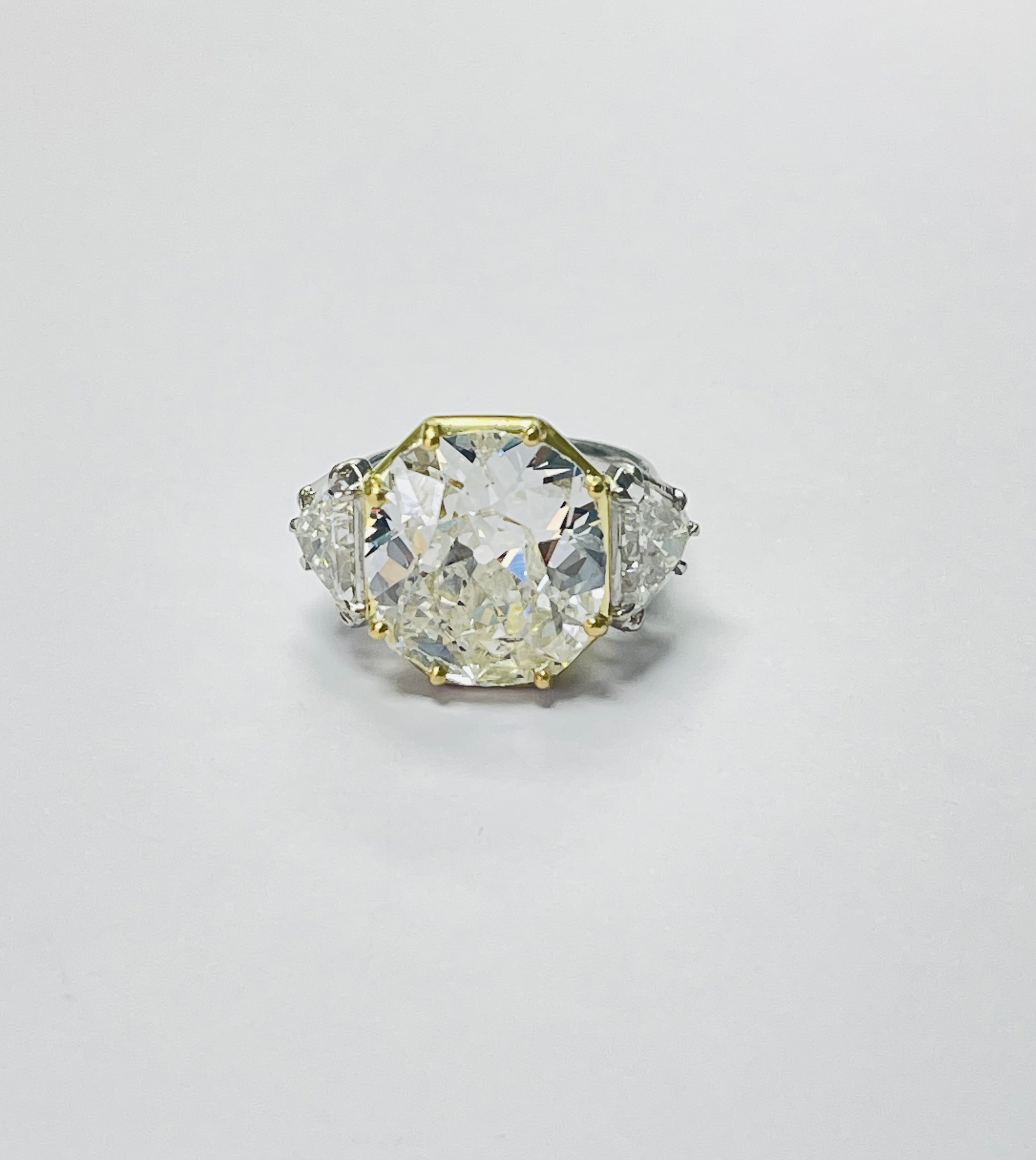 9.38 carats old mine cut diamond three stone ring in white and yellow gold. 

The details are as follows; 

Old Mine Cut Diamond weight : 9.38 carats ( G color and SI clarity ) 
Shield cut diamonds weight  : 2.25 carats approximately ( H color and