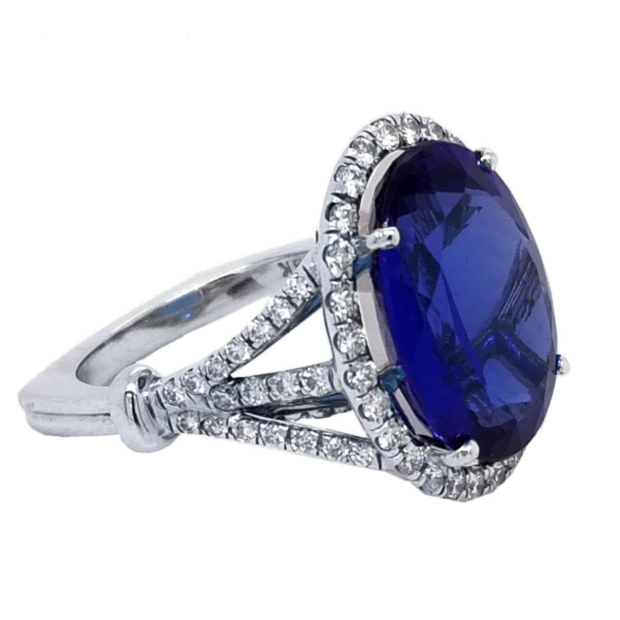 A beautiful color 9.38 Ct oval tanzanite set in the center of an 18K split shank pave set diamond engagement ring with a halo to create great contrast. 

Details:
Center Stone: 9.39 carat Oval tanzanite
Side Stone Diamonds: 0.91 total carat weight,