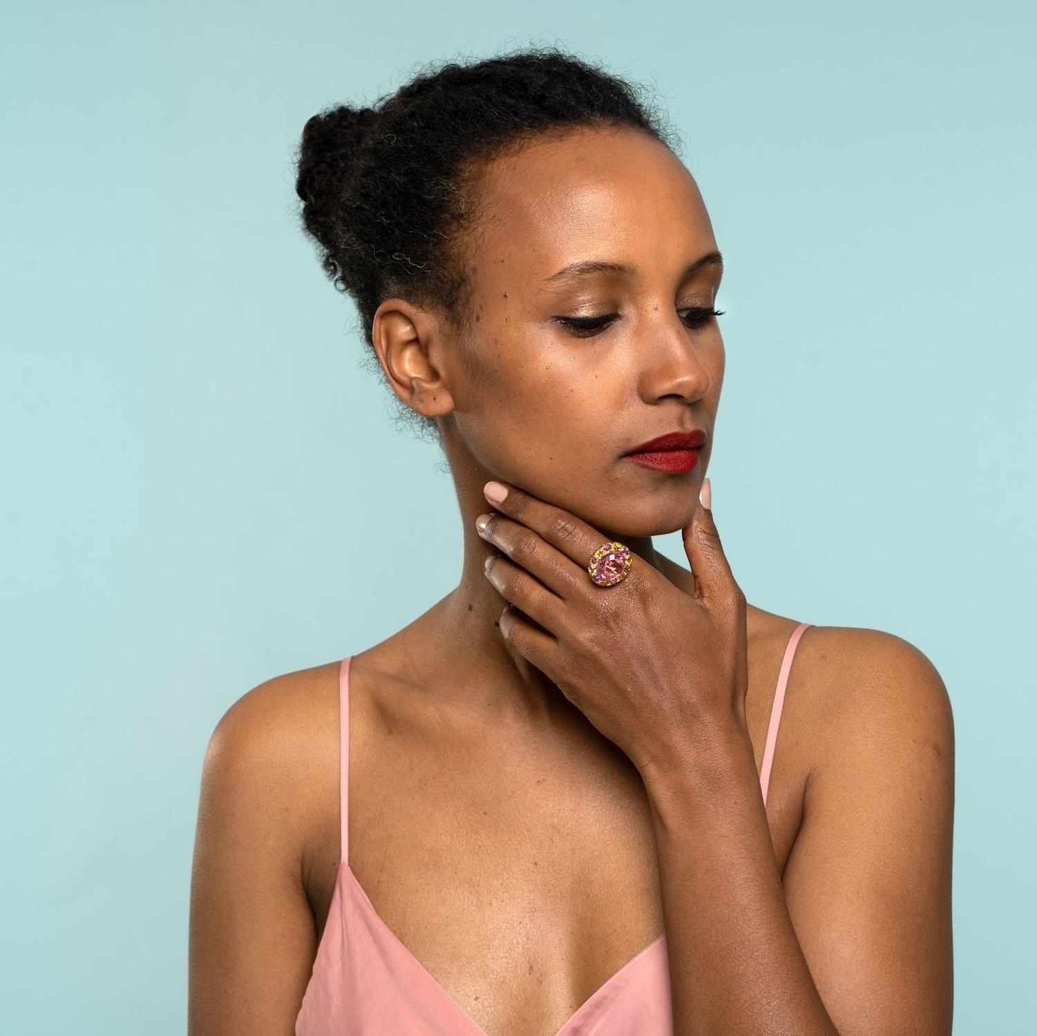 

This serious statement pink spinel cocktail ring is one-of-a-kind. Handmade using 18k gold, the central gemstone is a rare 9.3k pink spinel, with no heat treatment, making the colour particularly sought after.  The central gemstone is surrounded