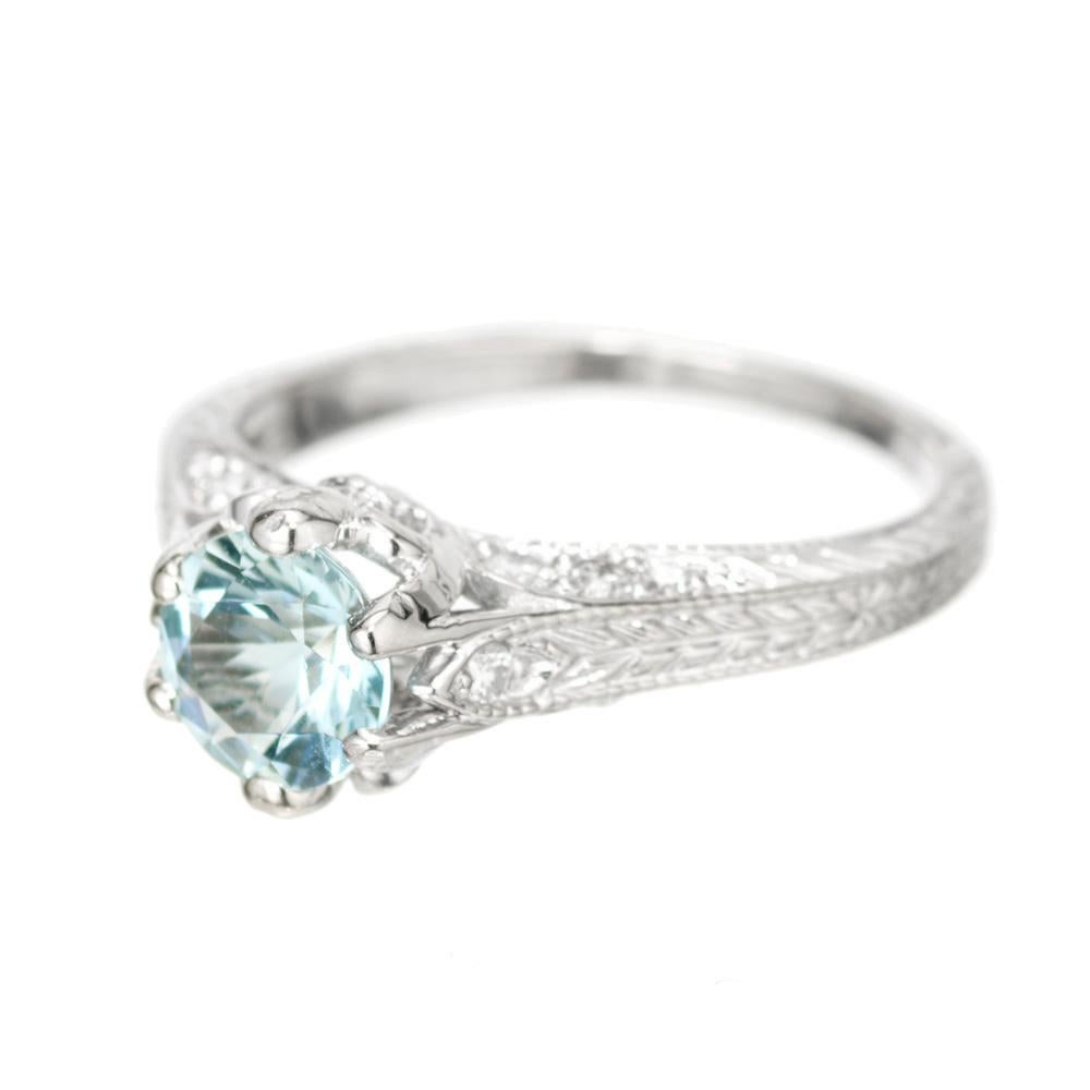 Aquamarine and diamond engagement ring. .94ct round blue aqua in a 14k white gold setting with 14 round brilliant cut accent diamonds.  

1 round blue aqua, approx. .94cts
14 round brilliant cut diamonds, H-I VS-SI approx. .25cts
Size 7.5 and