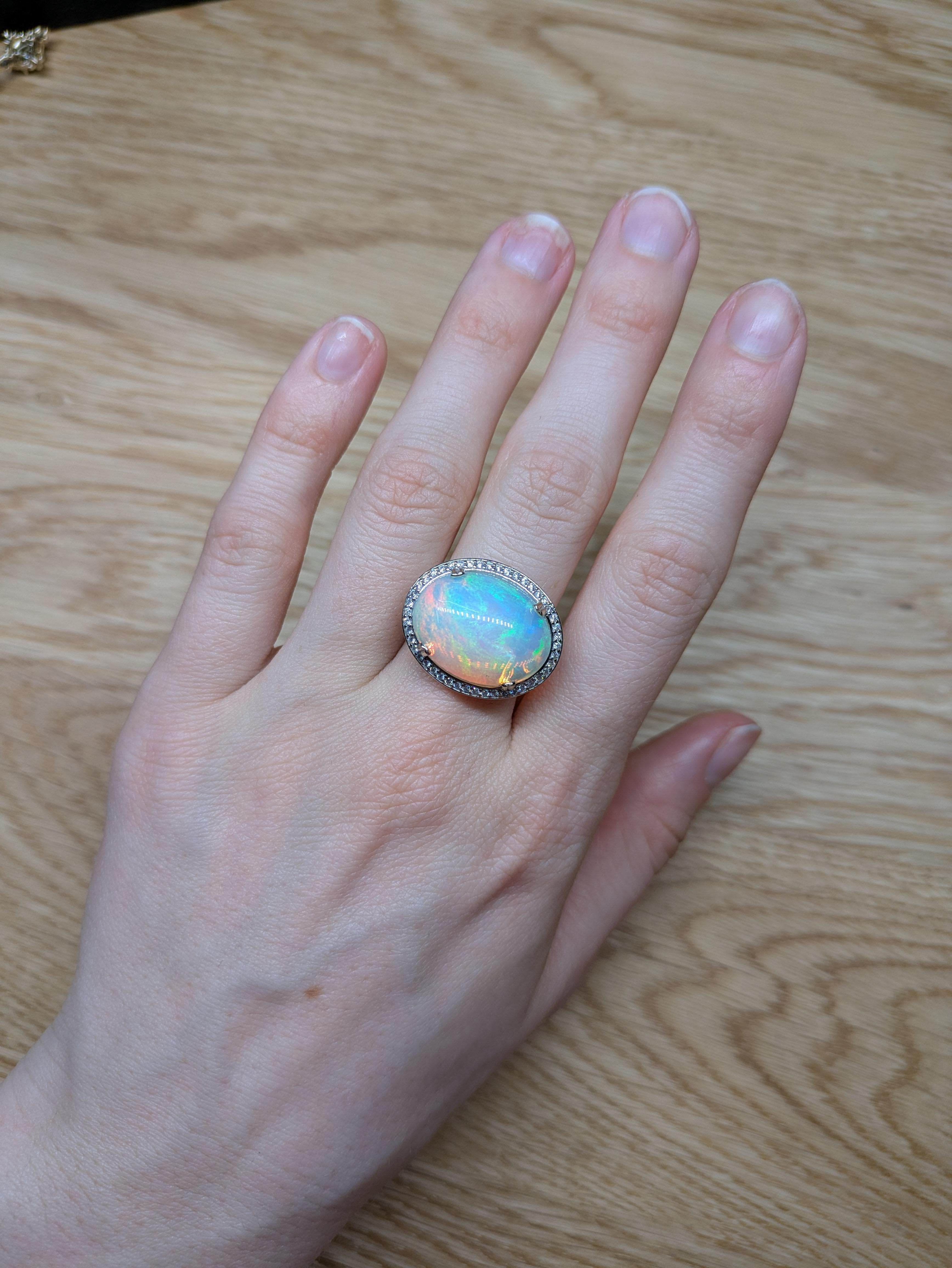 Faites une impression audacieuse avec cette magnifique bague en opale de 9,43ct, mettant en valeur une opale brillante de 20x15mm encadrée d'un halo de diamants naturels extraits de la terre. Sertie d'or massif 14K, cette pièce d'apparat rayonne