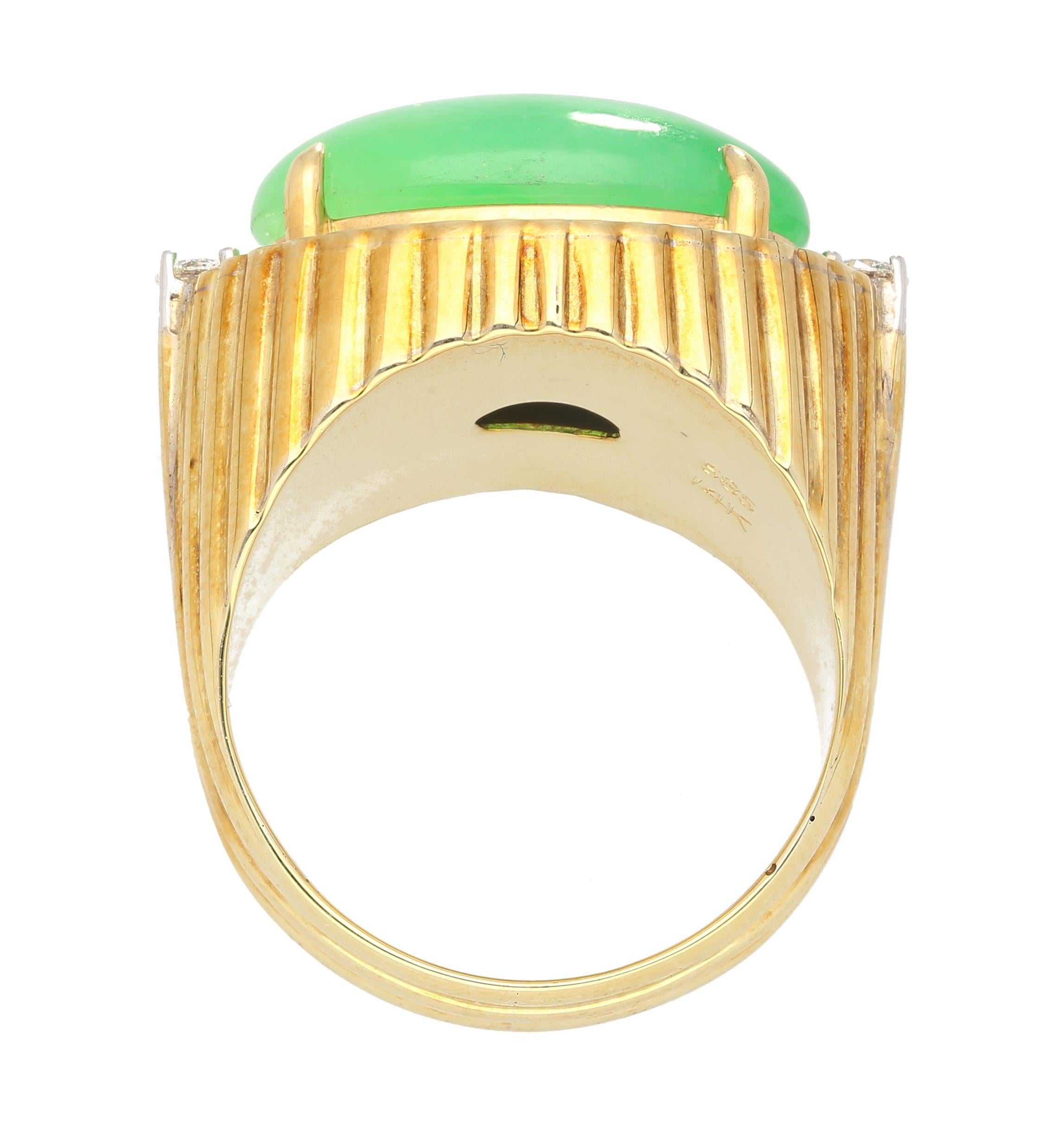 Oval cabochon cut 9.40 carat green Fei Cui Jadeite Jade ring. Grade A untreated jade with excellent color and luster. Adorned with 2 round cut diamonds of 0.15 carats total. Featuring a textured gold line ring shank. Ideal as a mens pinky or ladies