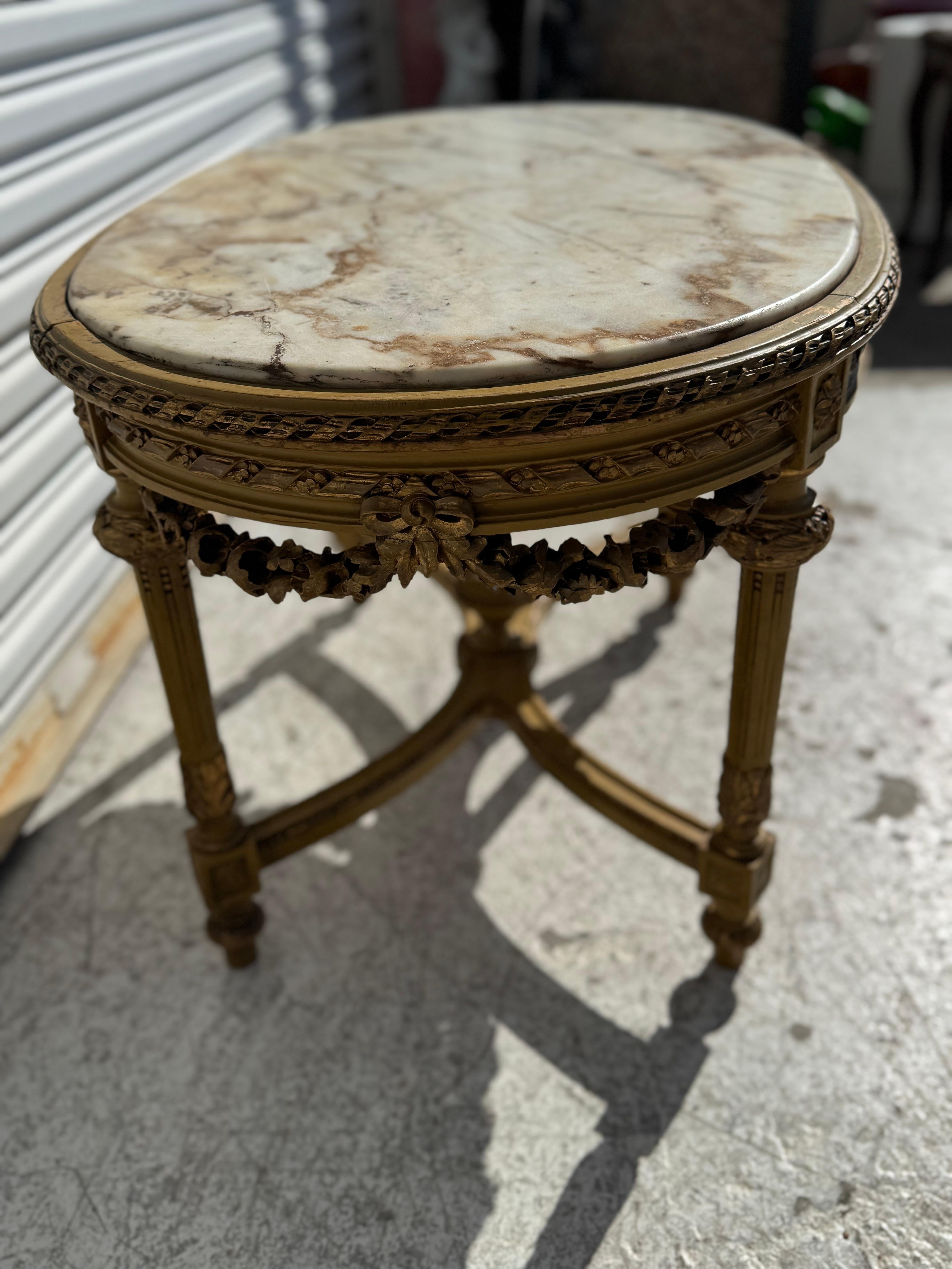 This coffee table is made in the Louis XVI style.
Its oval shaped and is highly carved.
The legs are columned and connected by arched stretchers with a finial in the center. The skirt is highly carved with a diamond beaded edge.