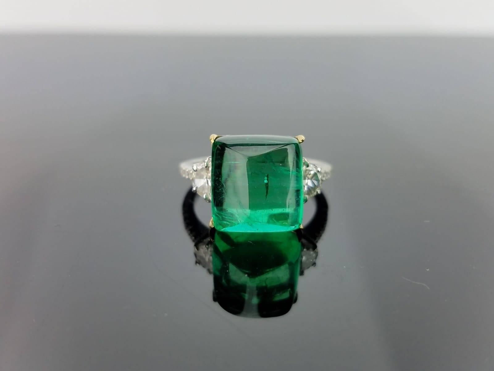 A classic three stone ring, with a 9.43-carat high quality and clarity Zambian Emerald centre stone and 2 half-moon side stones and 18K gold diamond band. 

Stone Details: 
Stone: Emerald
Carat Weight: 9.43 Carats

Diamond Details: 
Total Carat