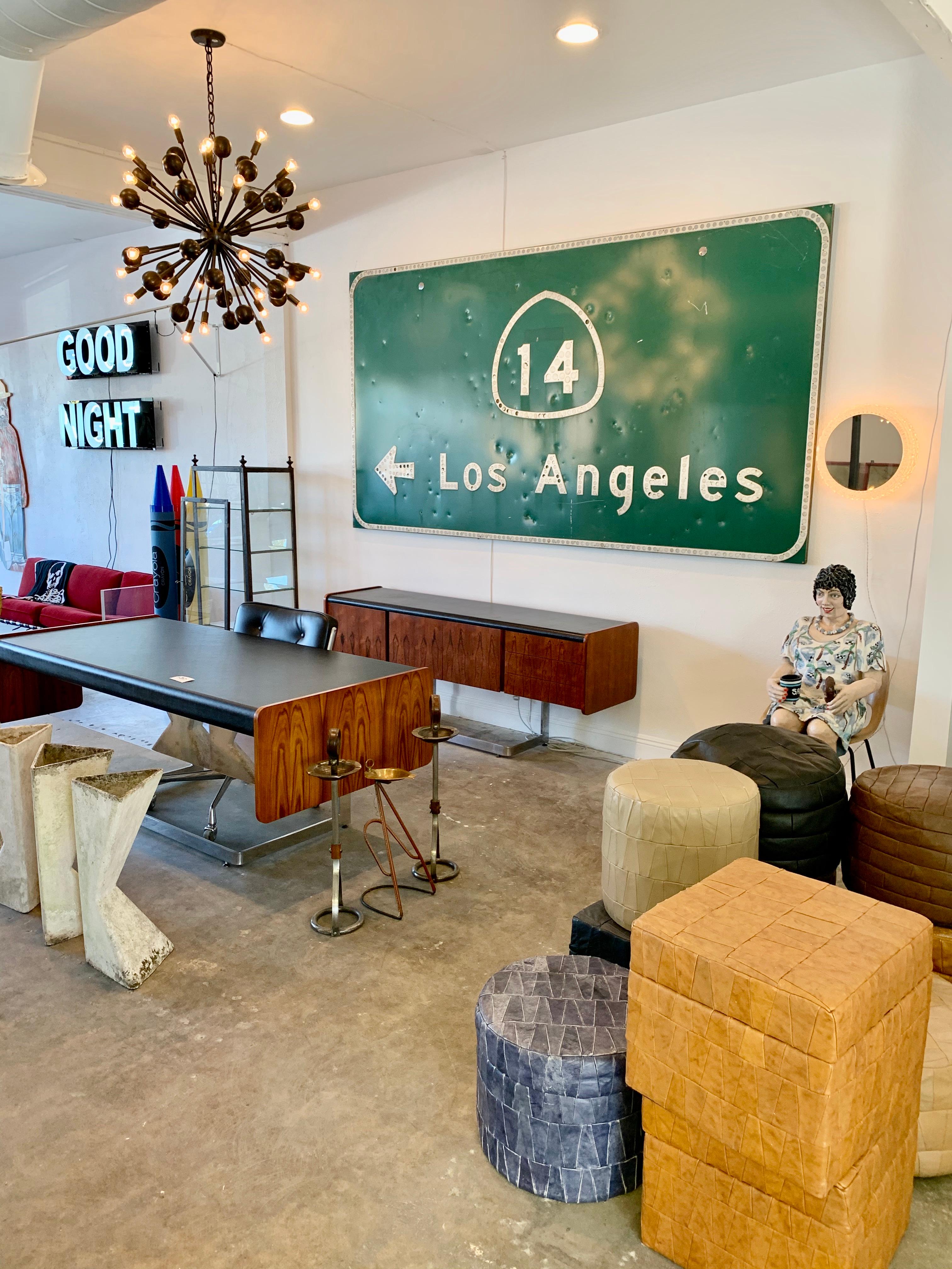 Super cool Los Angeles freeway sign. The sign is from State Route 14 which connects Los Angeles to the Mojave Desert. Great piece of California history. Just under 10 feet wide and 5 feet tall. Retired green aluminum sign with cat eye reflectors.