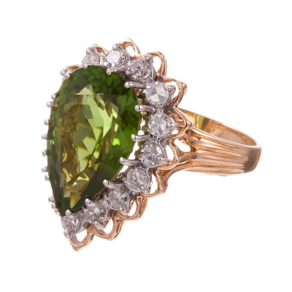The “pear peridot” ring… say it fast three times! A classic style, with an un-classic center stone. A 9.50 carat pear brilliant peridot, surrounded by .50 carats of brilliant round diamonds, set in 14k yellow and a hint of white gold. Despite its