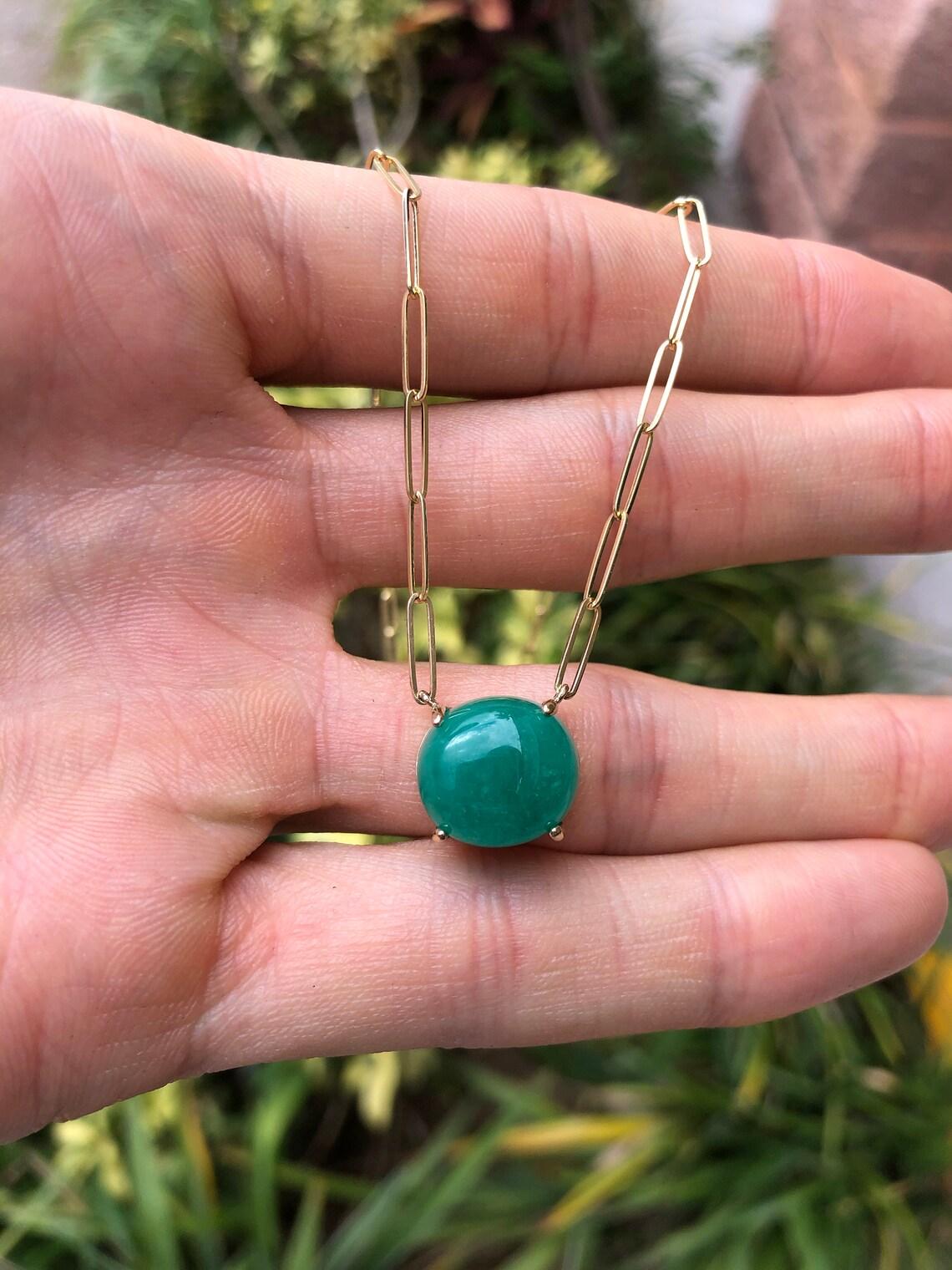 Featured here is a large and rare 9.50-carat stunning, Colombian emerald stationary necklace in fine 14K yellow, rose, or white gold. Displayed in the center is a rich dark green emerald, accented by a simple four-prong gold mount, allowing for the
