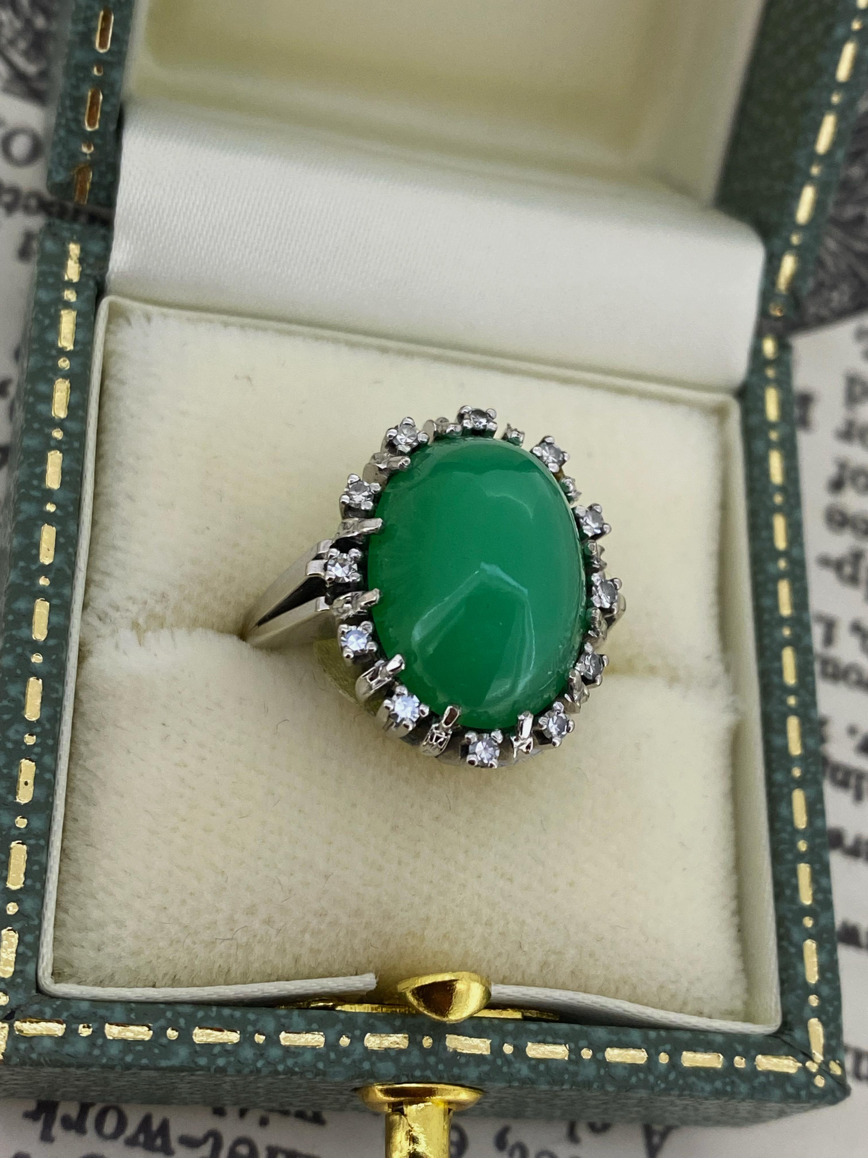 Este anillo de cóctel hecho a mano está exquisitamente elaborado en oro blanco de 14 quilates,  
con un racimo de gemas de primera calidad, formando una flor

Centrado de un cabujón ovalado de Crisoprasa natural
de color verde vivo medio distintivo