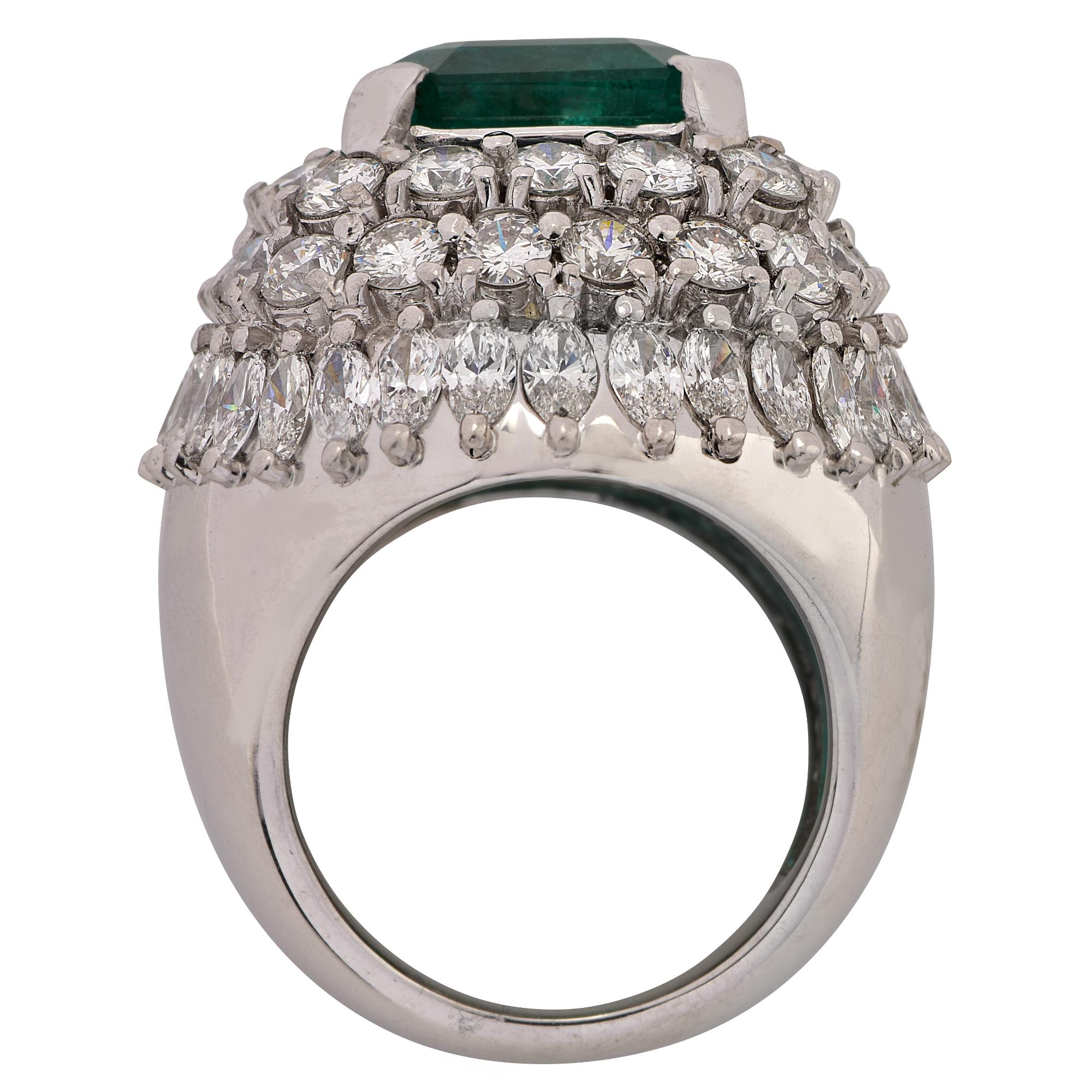 Stunning ring crafted in 18 karat white gold featuring a vibrant green emerald cut emerald weighing 9.51 carats, surrounded by 36 round brilliant cut diamonds weighing approximately 5 carats, G color, VS clarity, and 32 marquise cut diamonds