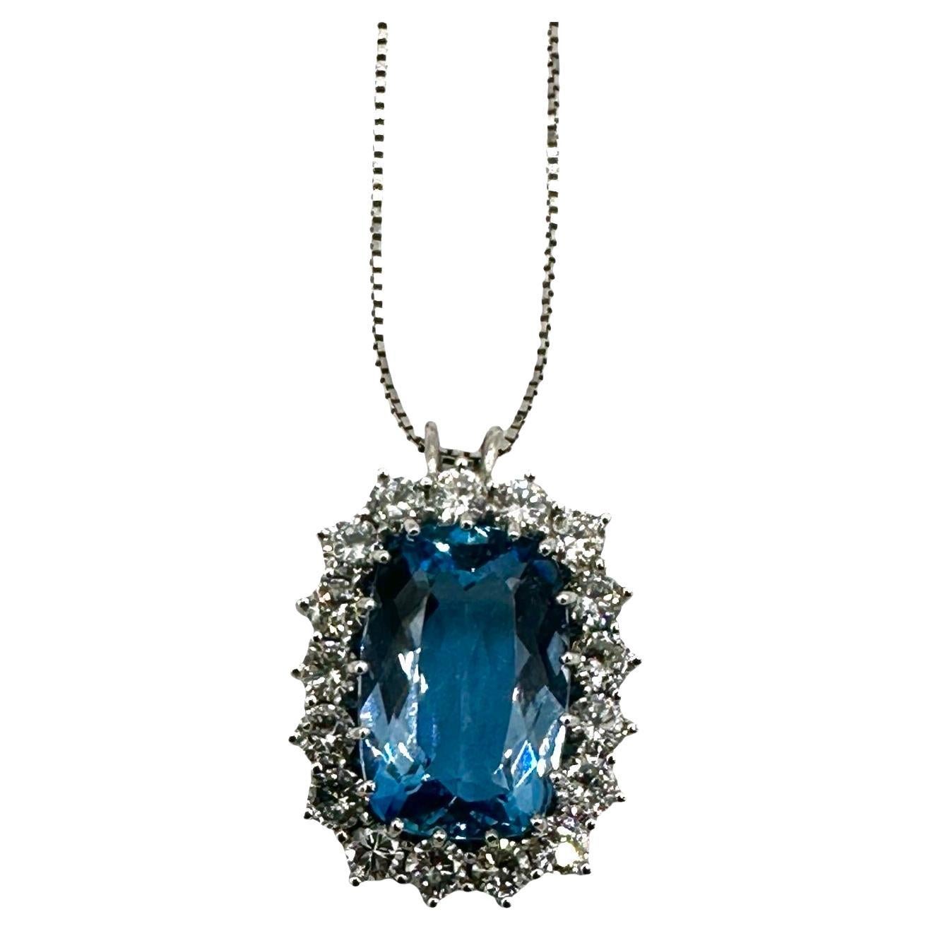 Una magnífica aguamarina azul en cojín de 9,52 quilates, engastada con garras y rodeada por una hilera de diamantes brillantes redondos, todo engastado en oro blanco de 18 quilates.  Los diamantes son de color F-G y claridad VS, con un peso total de