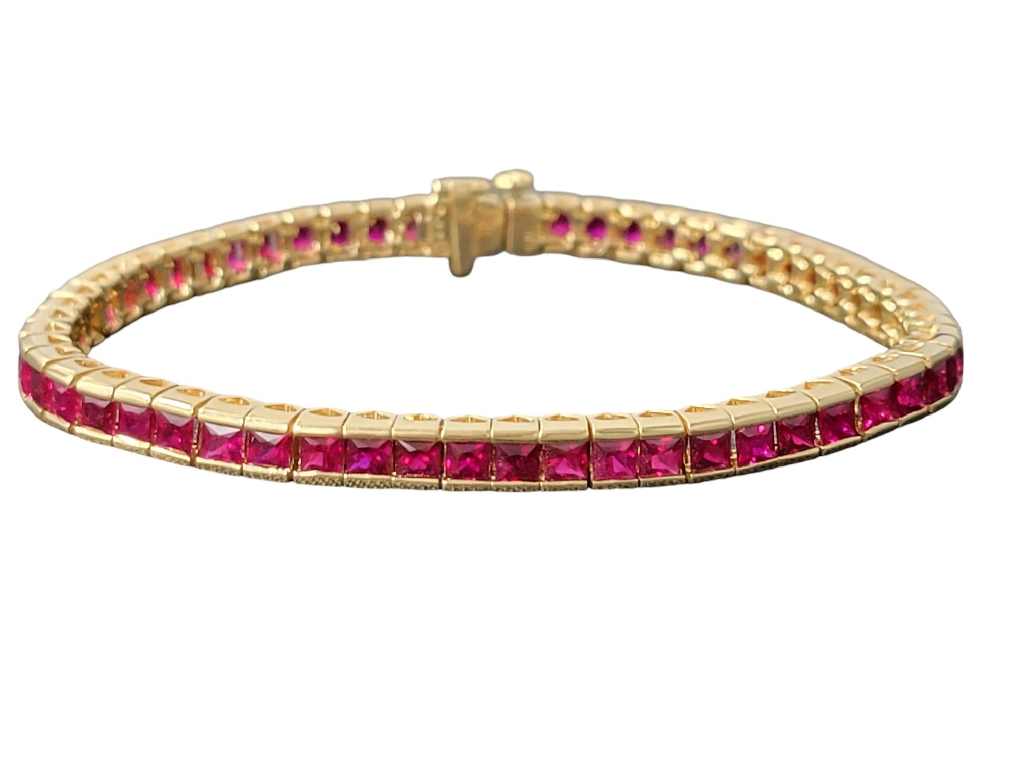 Indulge in the vibrant allure of luxury with this exquisite tennis bracelet, featuring a breathtaking array of channel-set princess-cut rubies, all beautifully crafted in 18 karat yellow gold. A true celebration of elegance and sophistication, this