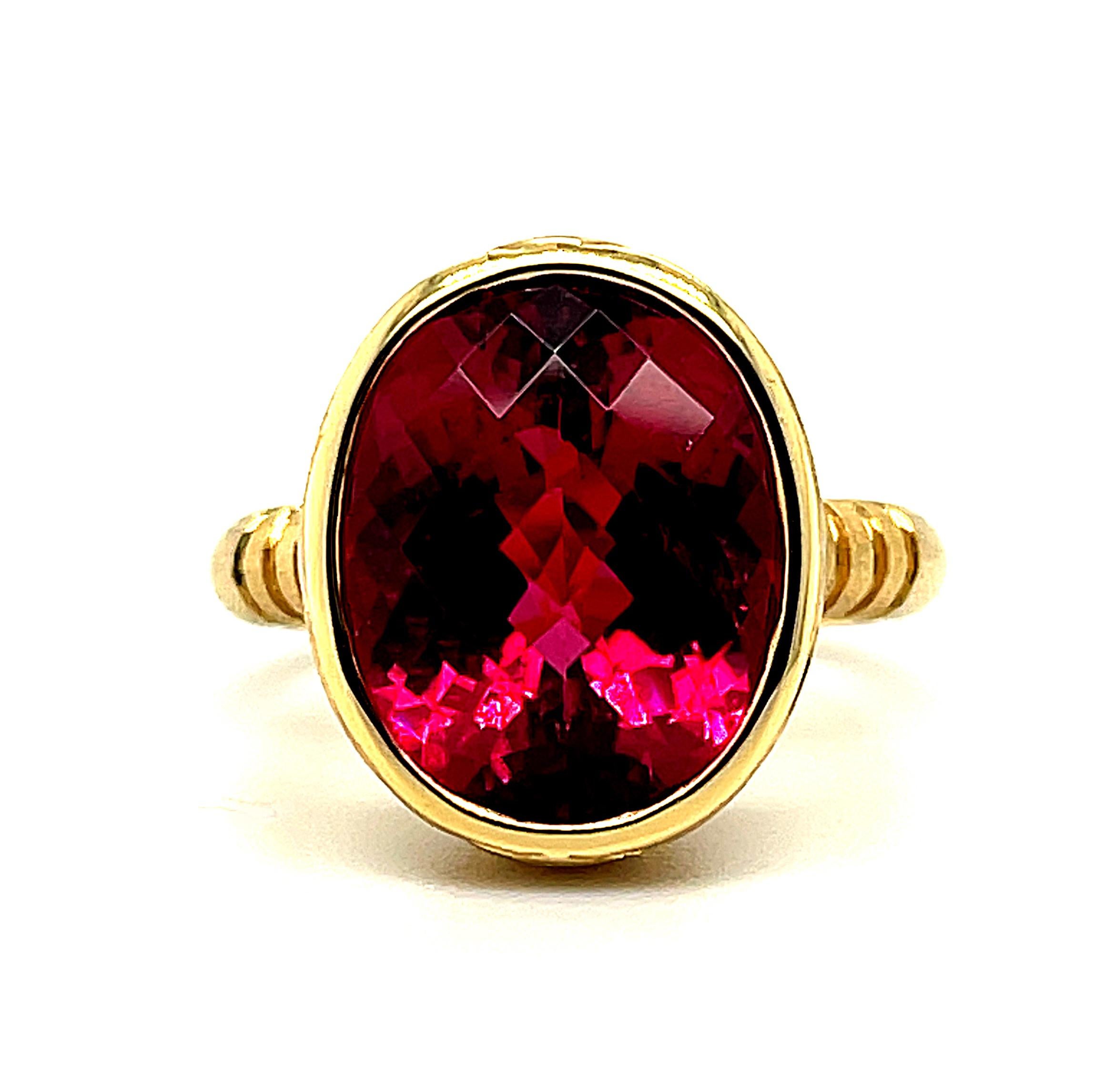 This handsome ring features a large rubellite tourmaline of exceptional quality; perfect for daytime or evening wear! The rubellite weighs 9.54 carats and has superior rich color and clarity. It is oval in shape, with an unusual 