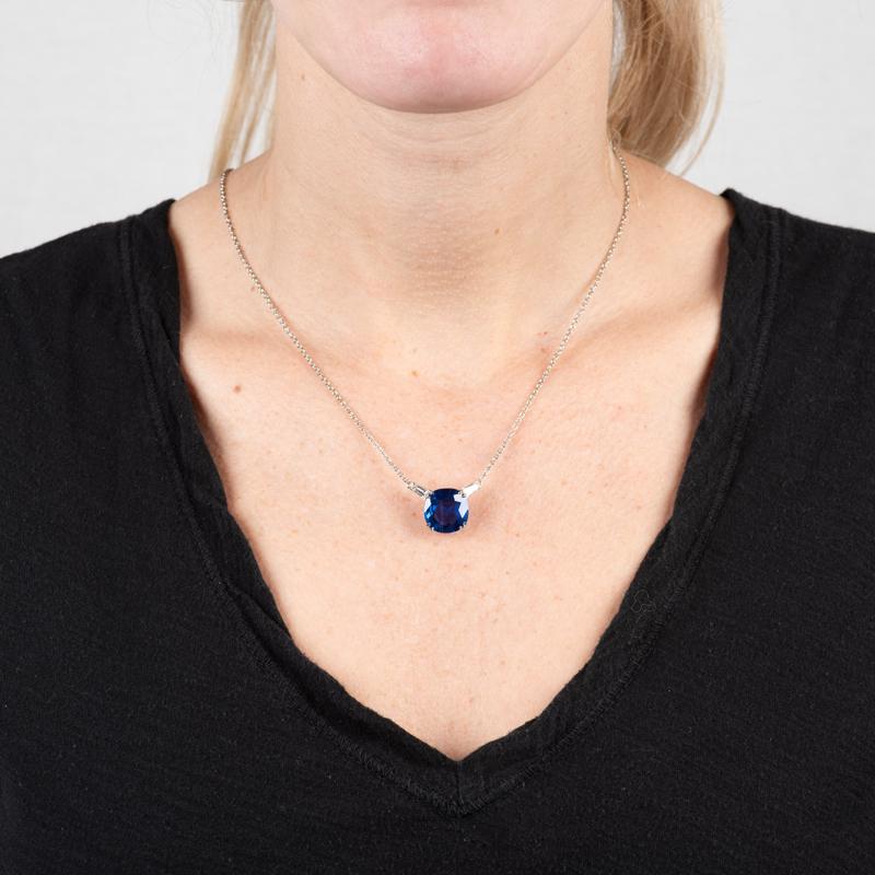This beautiful pendant necklace features a very special 9.57 carat cushion cut Sri Lankan blue sapphire, no heat, set in platinum accented by 0.50 carat total weight in tapered baguette diamond accents. It is set on a 18