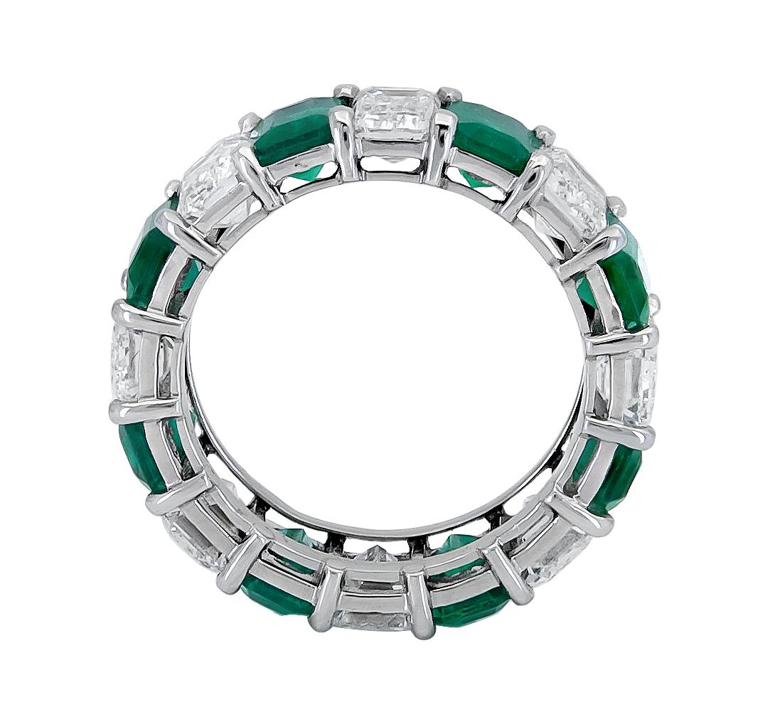 Showcasing alternating emerald cut green emeralds and diamonds, set in a classic eternity design. Emeralds and diamonds weigh 9.58 carats total. Size 5.75 US.

