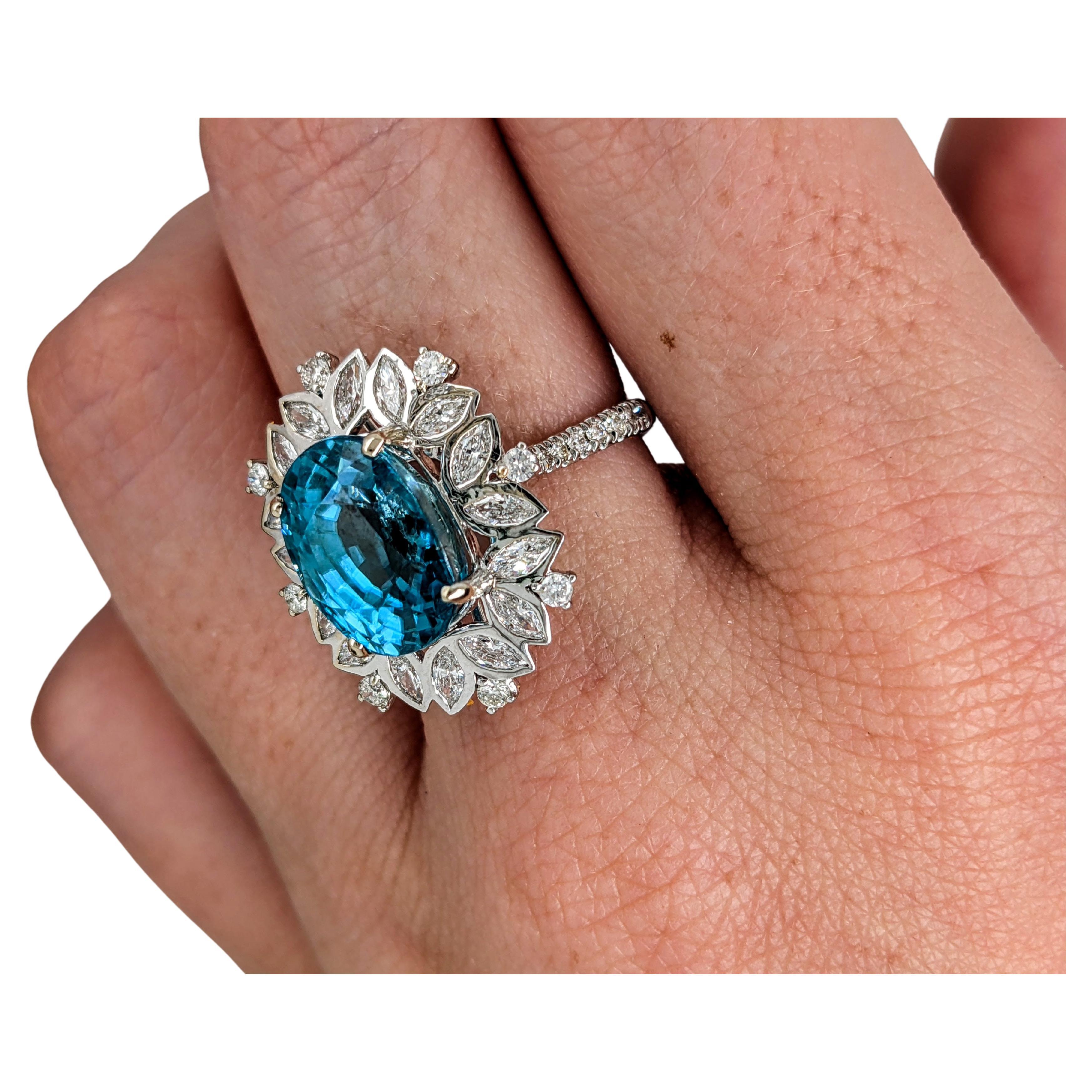 Introducing an exquisite blue zircon ring that commands attention with its breathtaking 10 carat center stone, adorned with the brilliance of natural diamond accents. This mesmerizing piece is a true marvel of beauty and sophistication, destined to