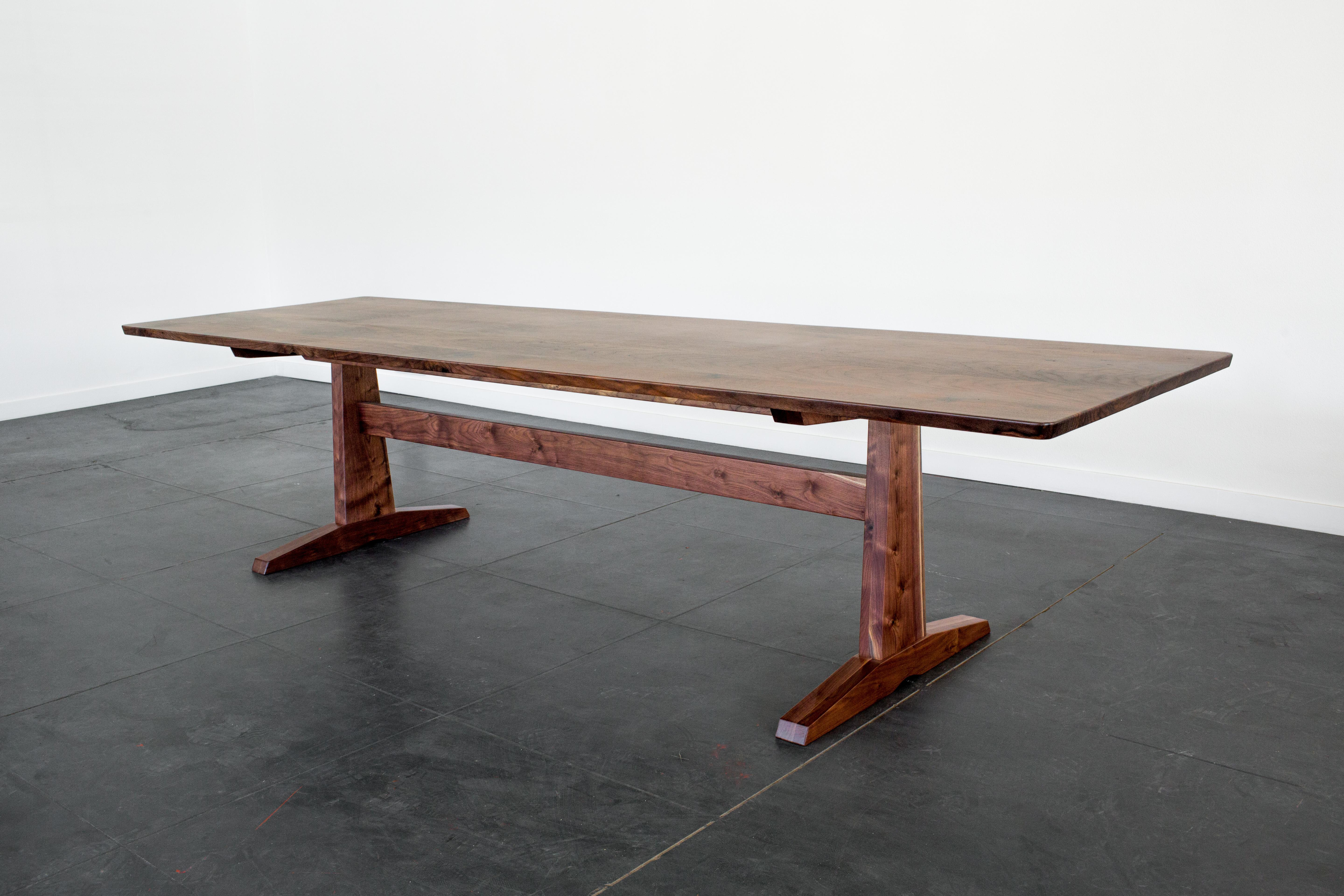 Purpose and design align in our Columbia Trestle Table. A solid trestle base is the grounding feature in this beautifully crafted modern take on a traditional form. Sleek with a strong profile, this table will be a stately presence in your dining or