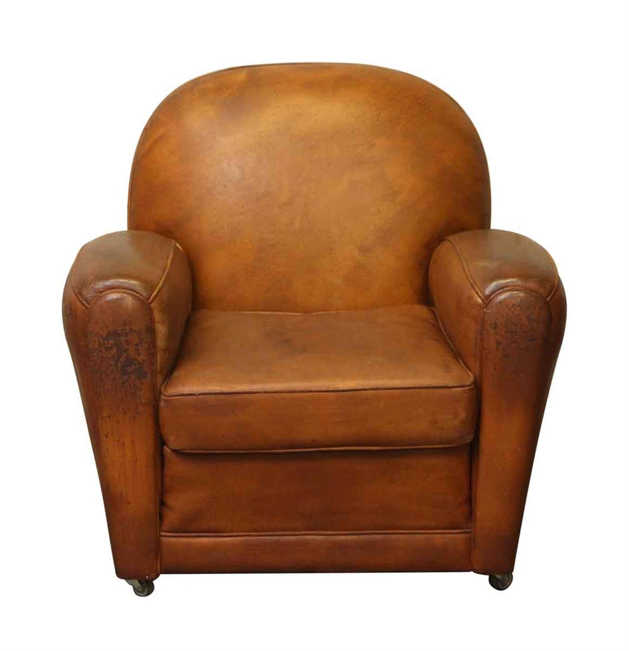 1960s French brown leather club chair with a rounded back and rolling wheels. This can be seen at our 5 East 16th St location on Union Square in Manhattan.