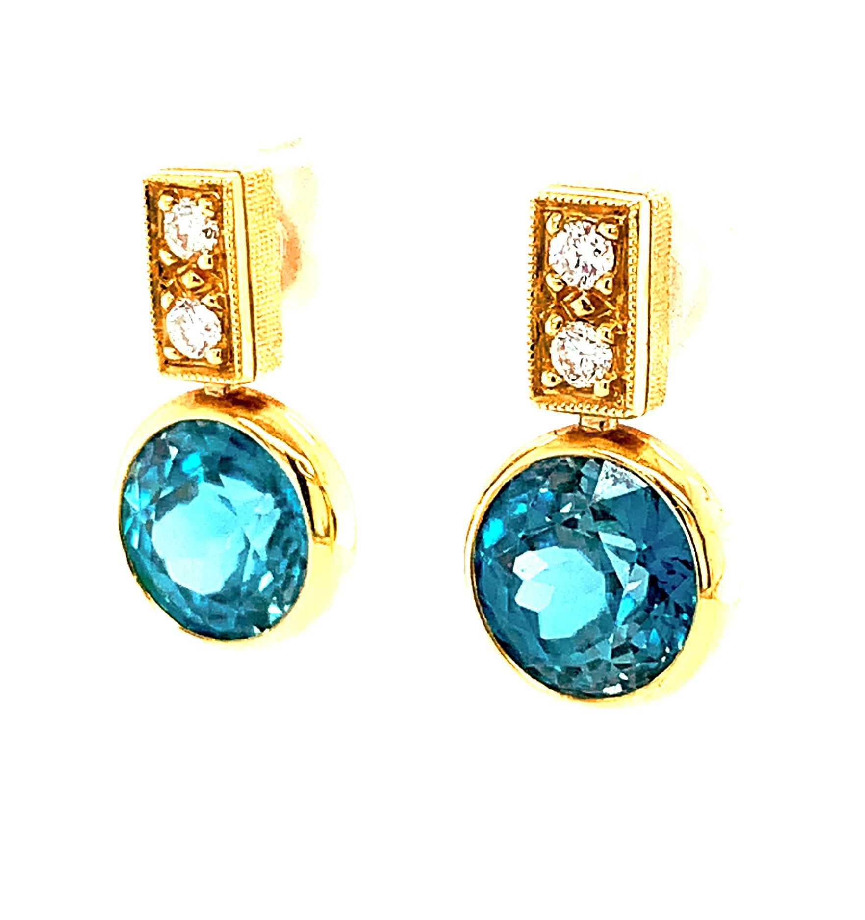 These beautiful drop earrings feature a gorgeous pair of gem-quality blue zircons set with diamonds in 18k yellow gold. It is rare to find a matched pair of large, round blue zircons with such vibrant color! This pair weighs 9.64 carats and packs a