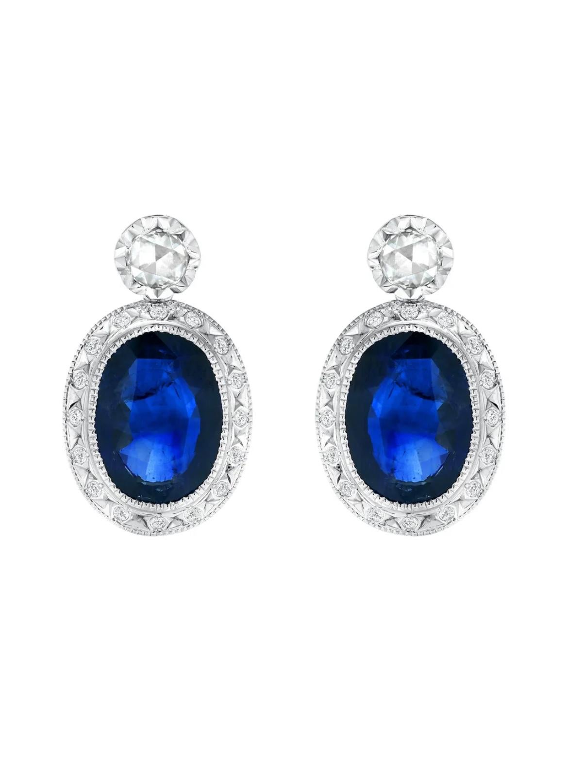 9.65ct Blue sapphires are paired with two rose-cut diamonds and numerous round white diamonds, weighing a total of 0.86 carats in 18K white gold earrings.
