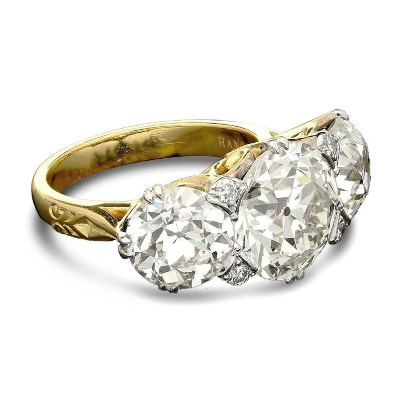 Old Mine European-cut diamond three stone ring in 18ct gold by Hancocks, a stunning contemporary three stone diamond ring with a beautifully hand crafted 18ct yellow gold carved half hoop setting, the bright and lively central old European-cut