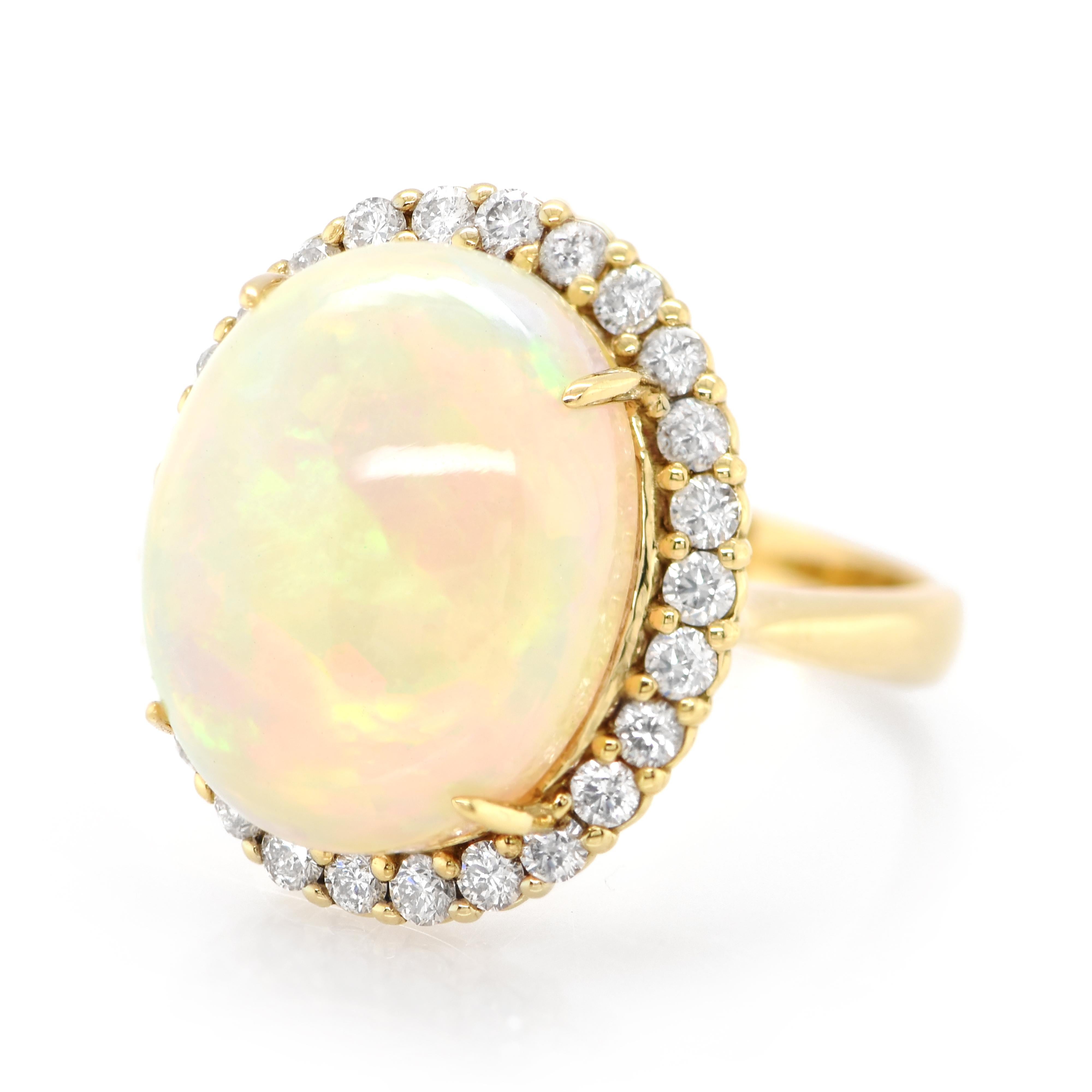 A beautiful ring featuring a 9.68 Carat Natural, White, Ethiopian Opal and 0.77 Carats of Diamond Accents set in 18K Gold. Opals are known for exhibiting flashes of rainbow colors known as 