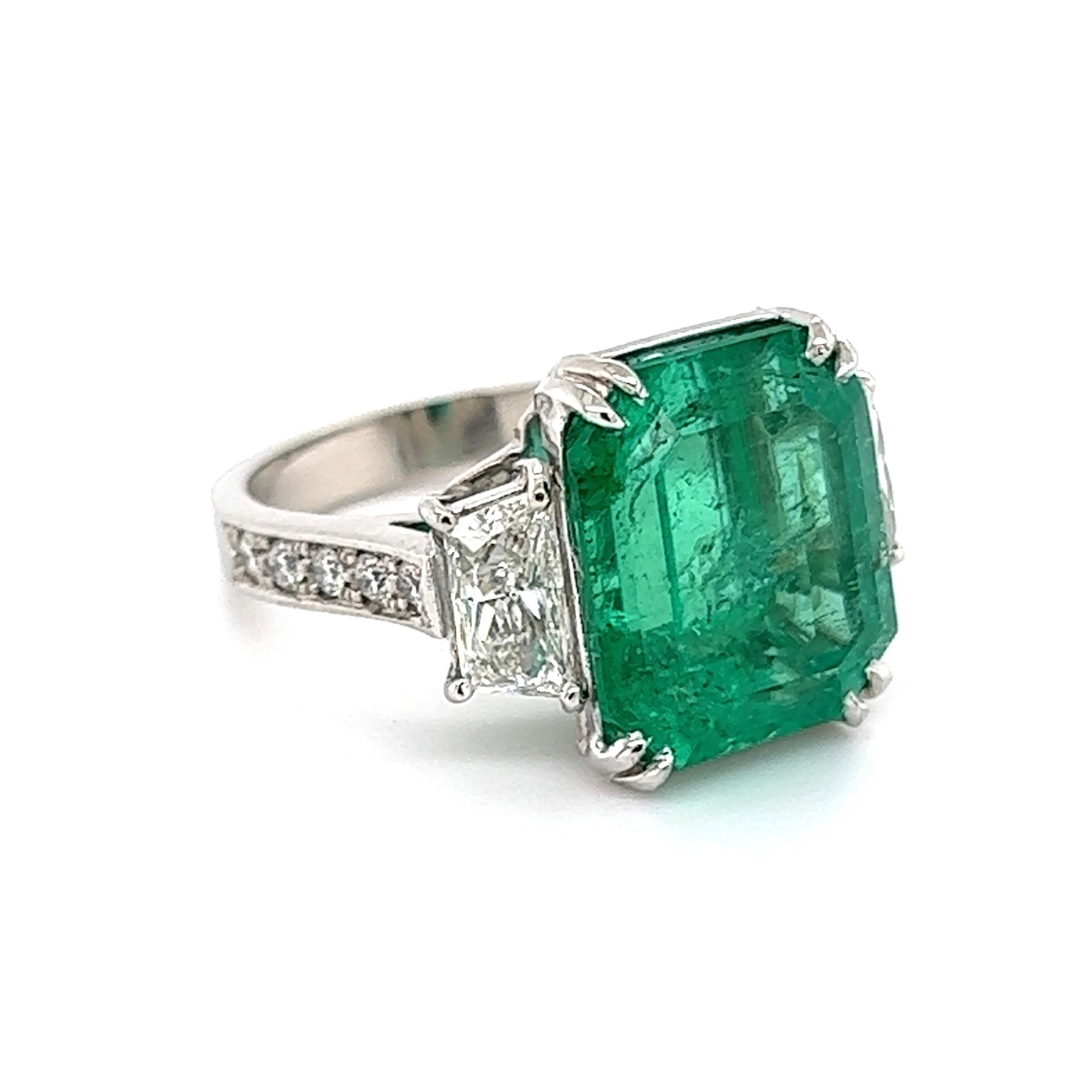 Simply Beautiful! Finely detailed Emerald and Diamond Three-Stone Trilogy Platinum Cocktail Ring, center securely nestled with an Emerald-Cut Emerald weighing approx. 9.70 Carat with a Diamond on both sides and including side Diamonds enhancing the