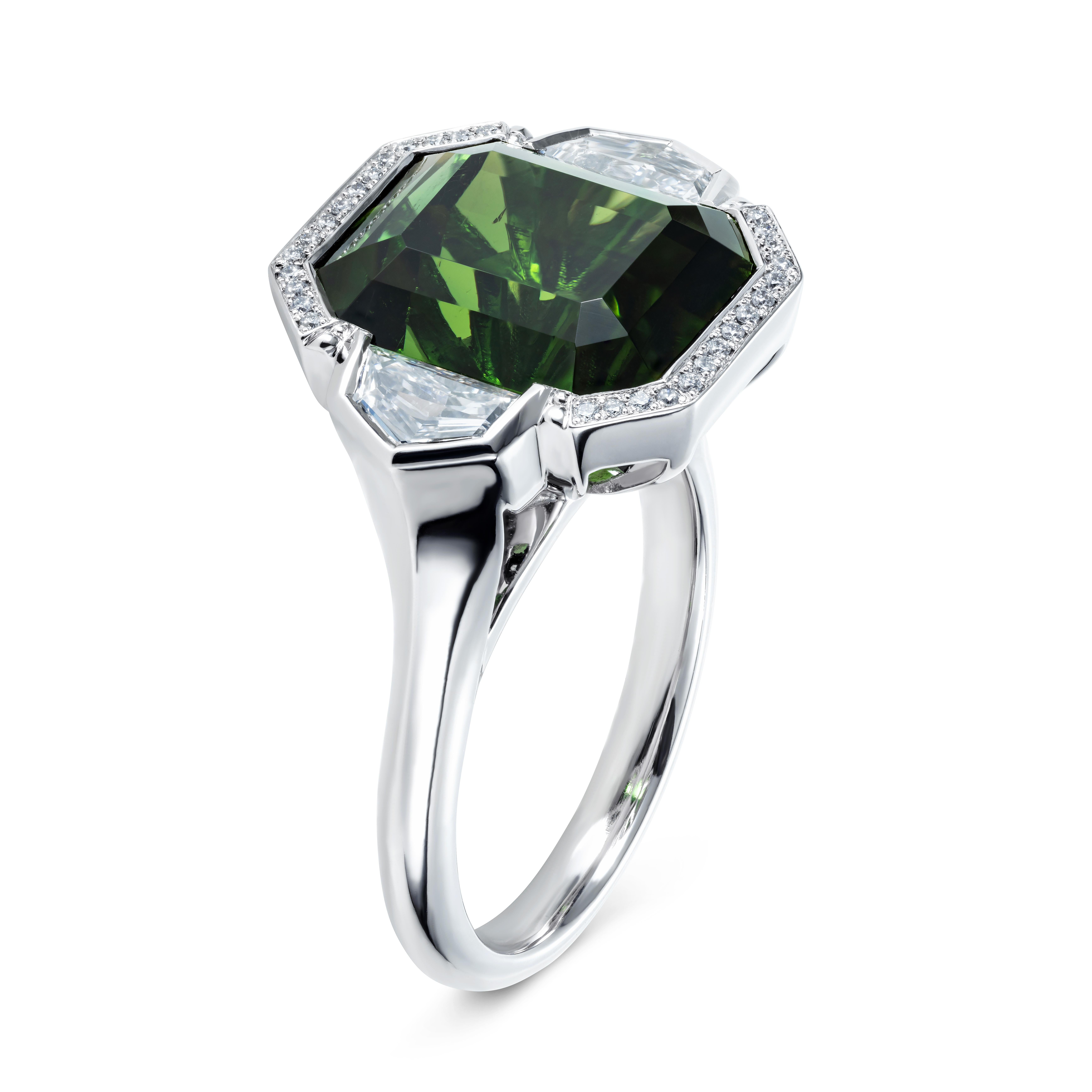 A simply stunning ring featuring a mesmerising green tourmaline.  The design is unique and skilfully made in our London workshop by a team of expert craftsmen.  We spotted the beautiful qualities of this 9.7 carat emerald cut tourmaline in its rough