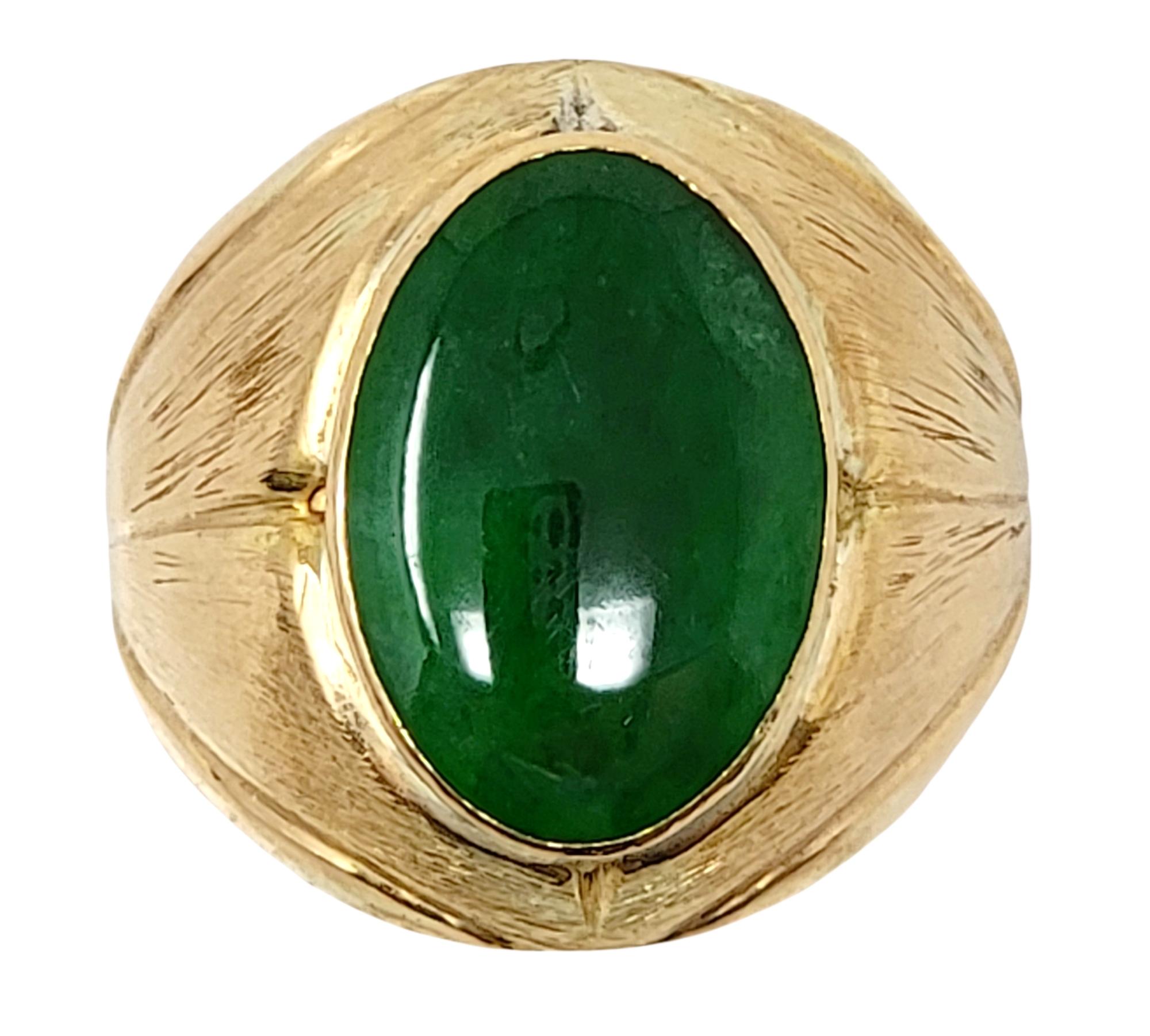 Ring size: 10.25

This bold 18 karat yellow gold and Jadeite cocktail ring is substantial in size and offers a stunning pop of color as it fills the finger. This is an undyed Jadeite cabochon stone, semi translucent, in a dark green color. 

Ring
