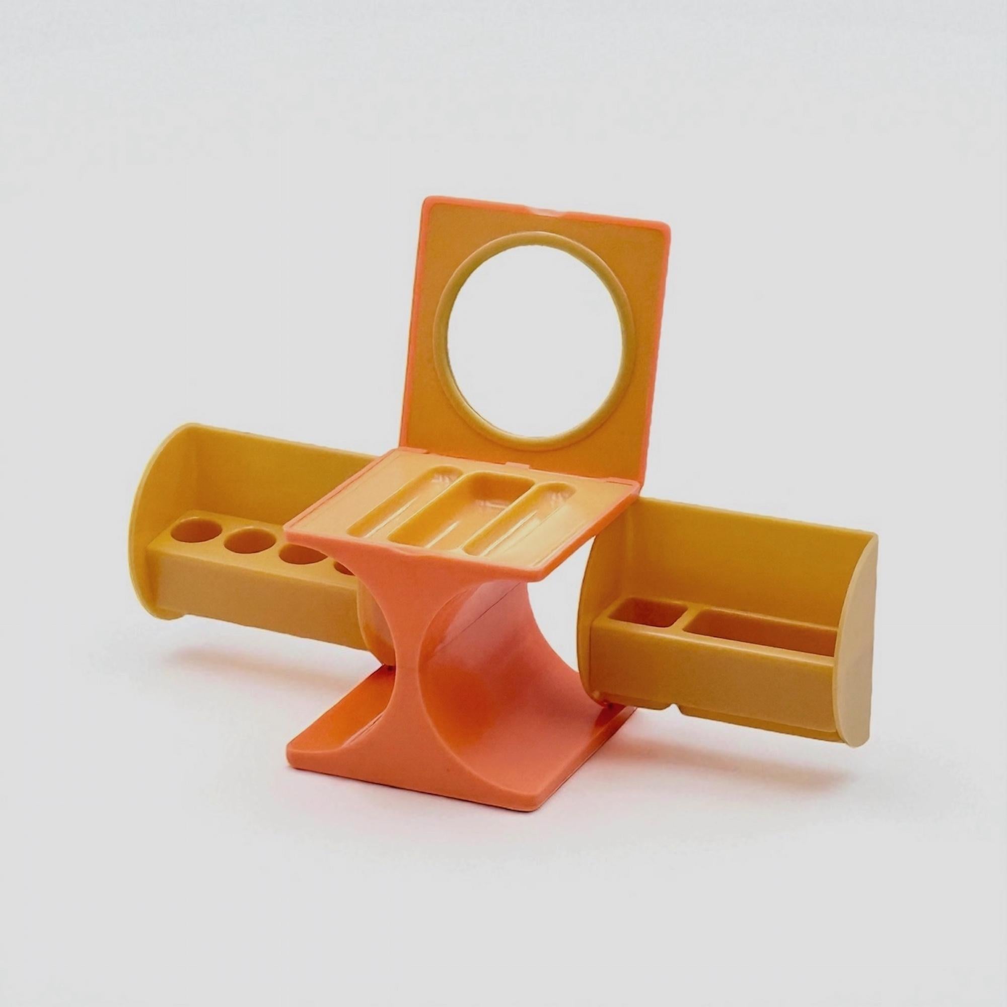 This vintage vanity box from Italy, dating to the 1970s, is a striking example of Space Age modular design. Molded in hard ABS plastic in a rare salmon and cream colorway, the piece takes the form of a compact cube when closed. Upon opening, it