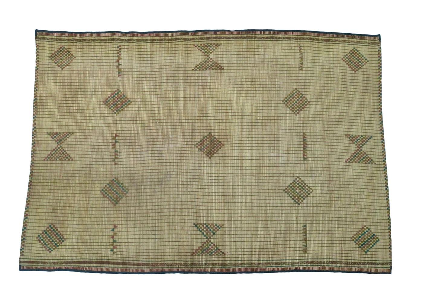 Stuoia Tuareg della Mauritania intrecciata a mano con canne di palma e pelle in un disegno tribale con simboli berberi.
Dimensioni: 6'7 x 9'7 