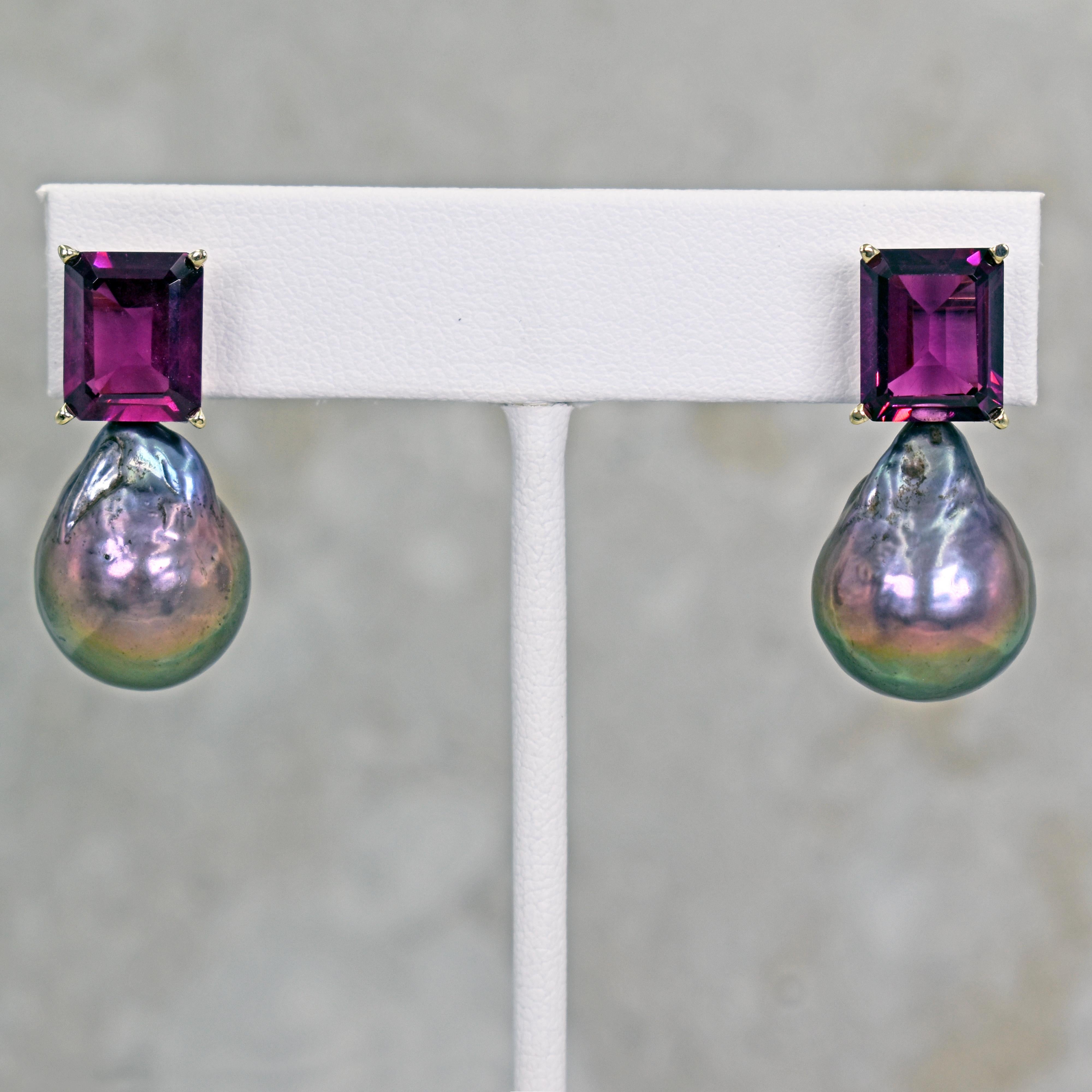 Gorgeous and unique 14k yellow gold stud earrings featuring two emerald-cut pinkish purple Rhodolite Garnet gemstones, totaling 9.73 carats, and Tahitian Baroque Pearls. Stud earrings are 1.19 inches or 30 mm in length. These artisan drop earrings