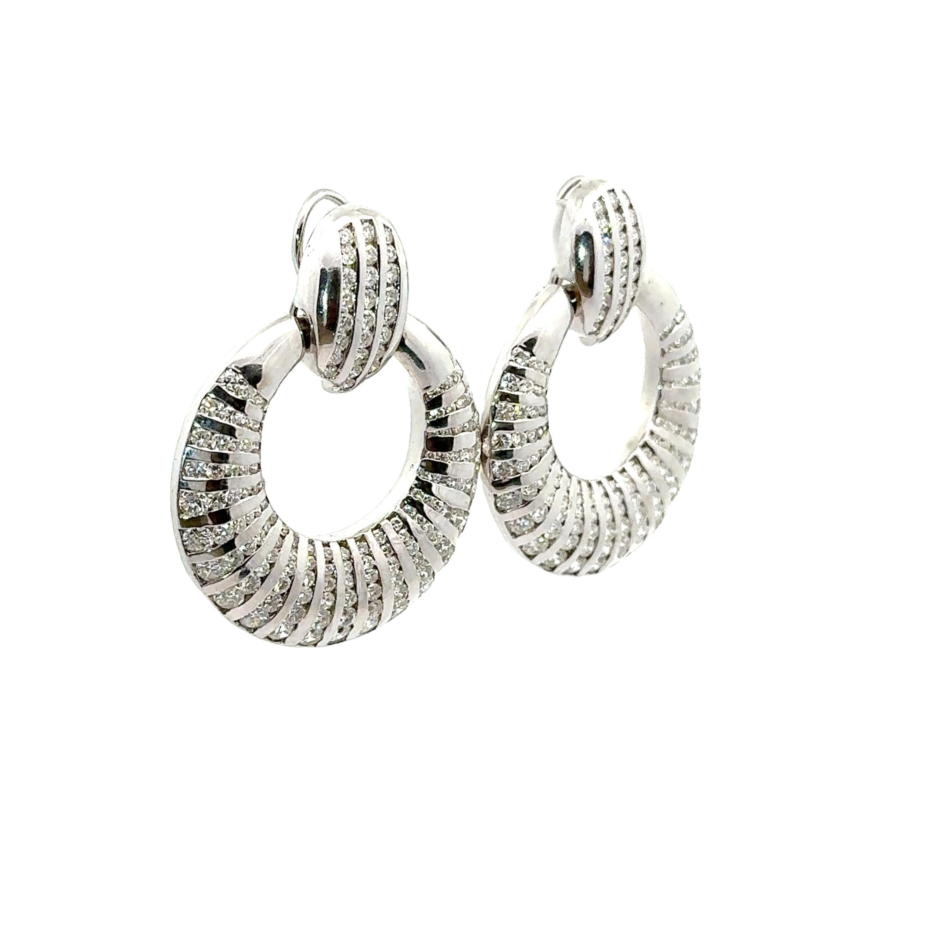Realizzati in oro bianco 18 carati, questi orecchini sono un'aggiunta straordinaria a qualsiasi collezione. Whiting, con 9,76 carati di diamanti bianchi rotondi, emana eleganza e brillantezza. Il design presenta cerchi concentrici con un motivo a