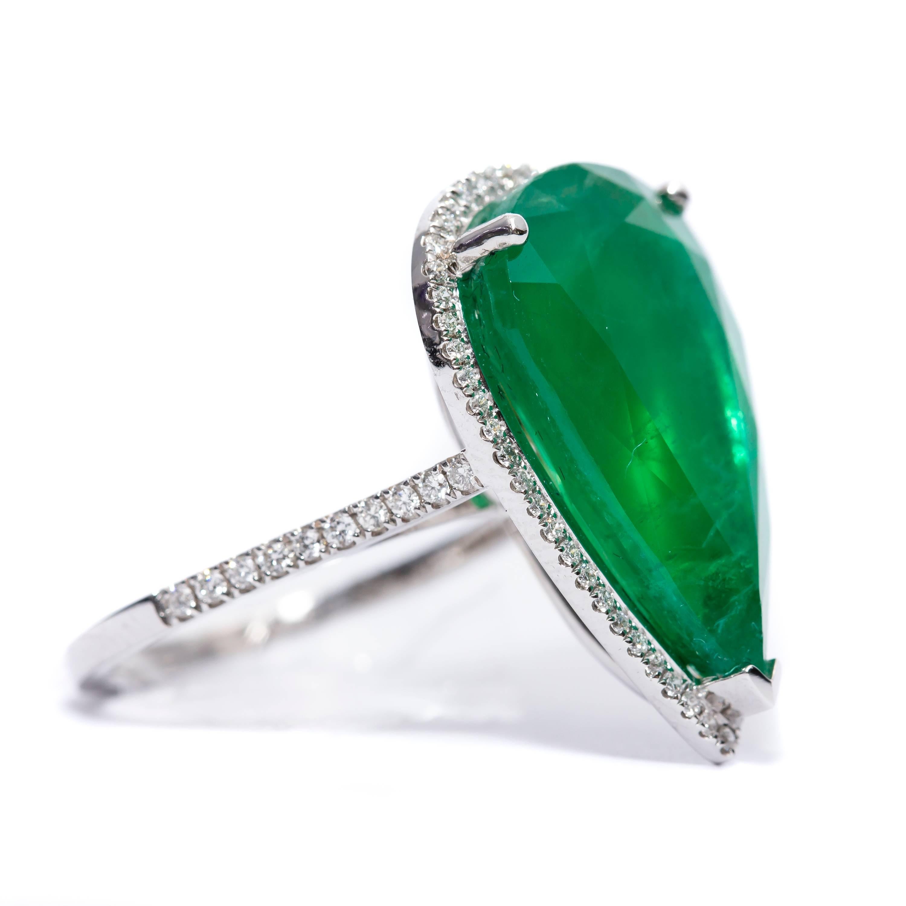 This extraordinary 9.78 Carat Pear Shaped Emerald Ring highlighted by a halo of 0.33 Carat dazzling Round Brilliant Diamonds for a stunning statement piece to add to any collection. Set in 18 Karat White Gold, British Hallmarked. UK size L, US size