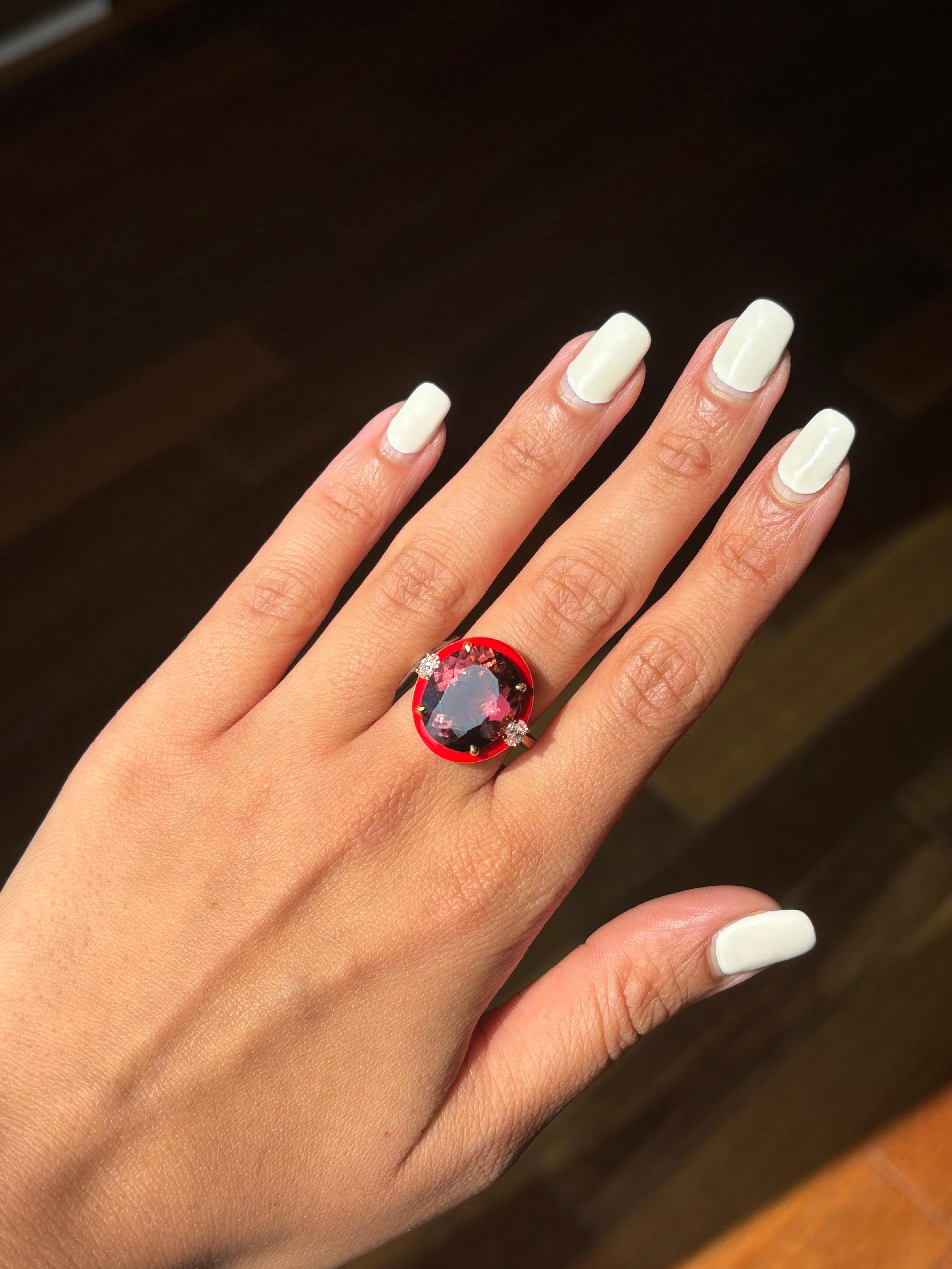Une bague de cocktail qui attire le regard, avec une tourmaline ovale de 9,78 carats au centre, entourée de détails en émail rouge, et des diamants ovales de 0,28 carat comme pierres latérales, le tout serti dans de l'or jaune 18 carats. La pierre