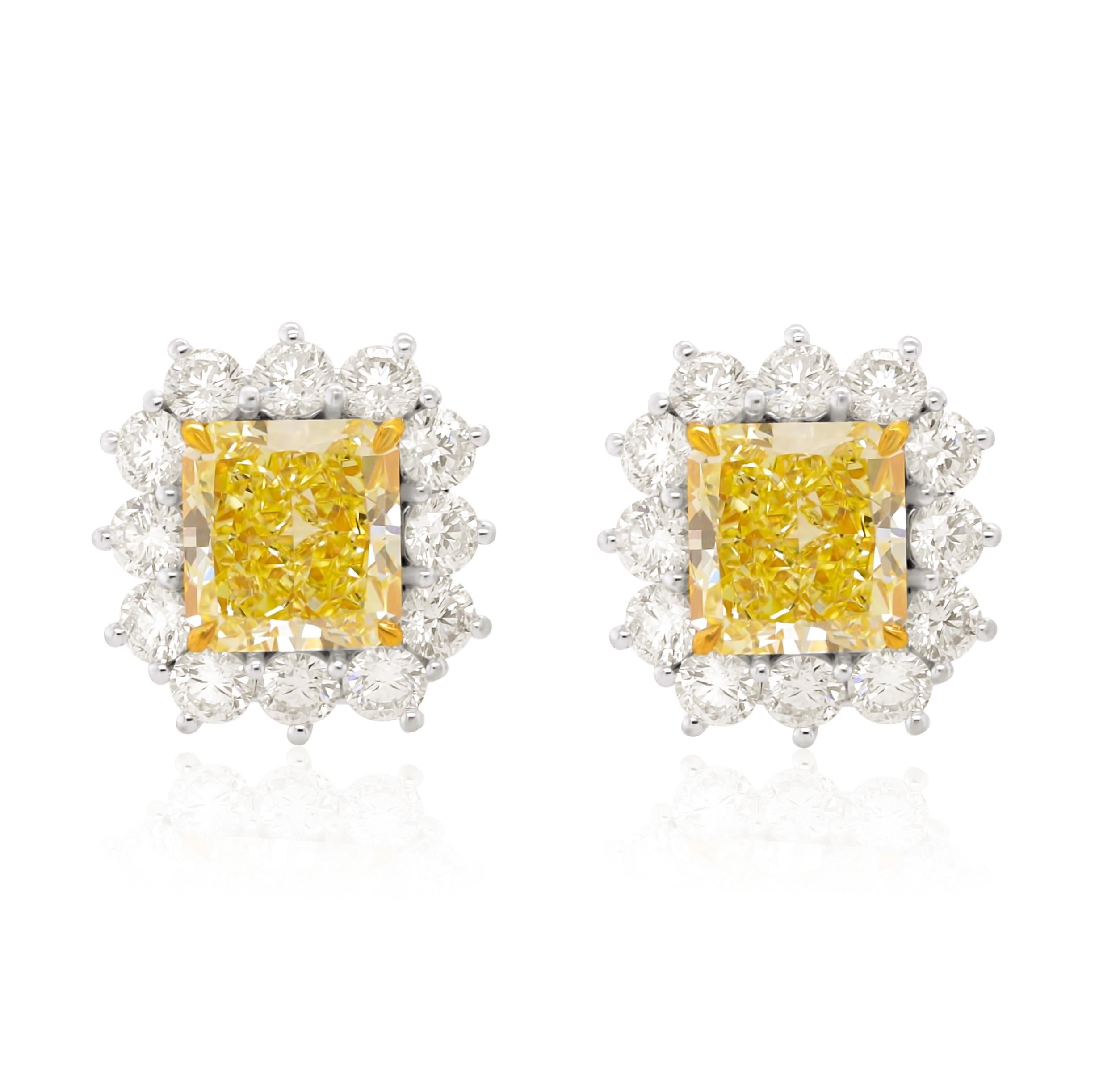 These beautiful earrings set with Natural Yellow Diamond totaling 6.79 Carats of Radiant Cut Fancy Light Yellow, VVS1 in clarity Diamonds, surrounded by 3.00 carats of diamonds. 
