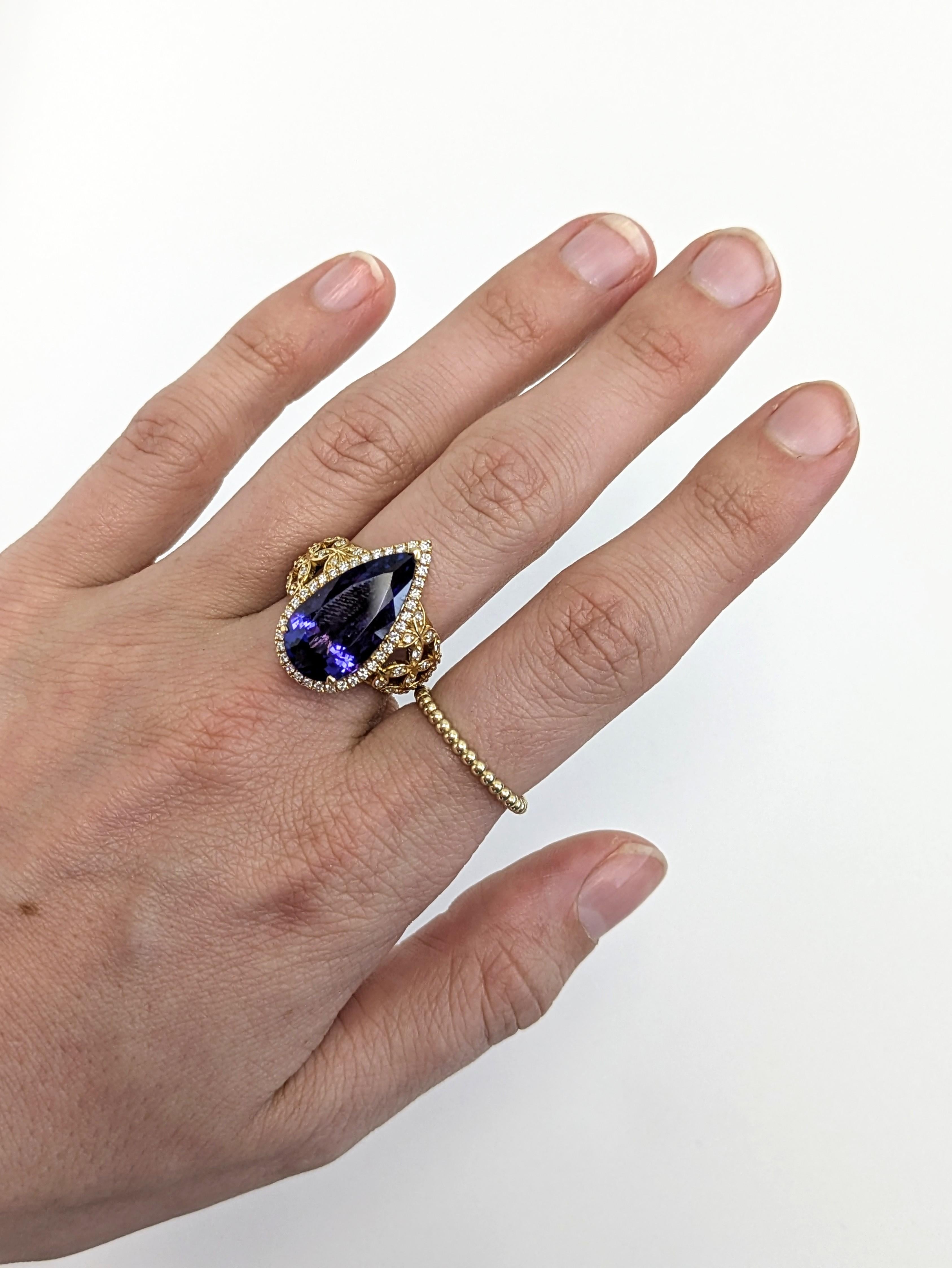 Faites une impression inoubliable avec cette bague en tanzanite de 9,7 carats en forme de poire. Dotée d'un halo de diamants étincelants et d'accents de diamants naturels en riche or véritable 18 carats, cette grande pièce luxueusement conçue