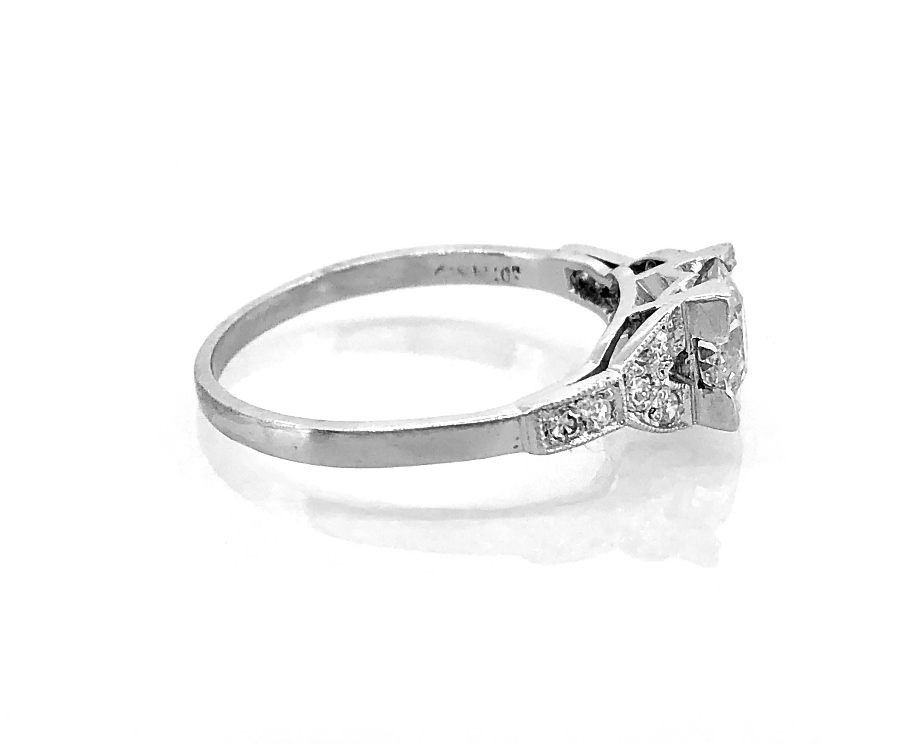 A bright and lively Art Deco diamond Antique engagement ring that features .98ct. European cut diamond with VS1 clarity and K color. Additional accenting single cut diamonds weigh .15ct. apx. T.W. and have VS1-VS2 clarity and G-H color. The mounting