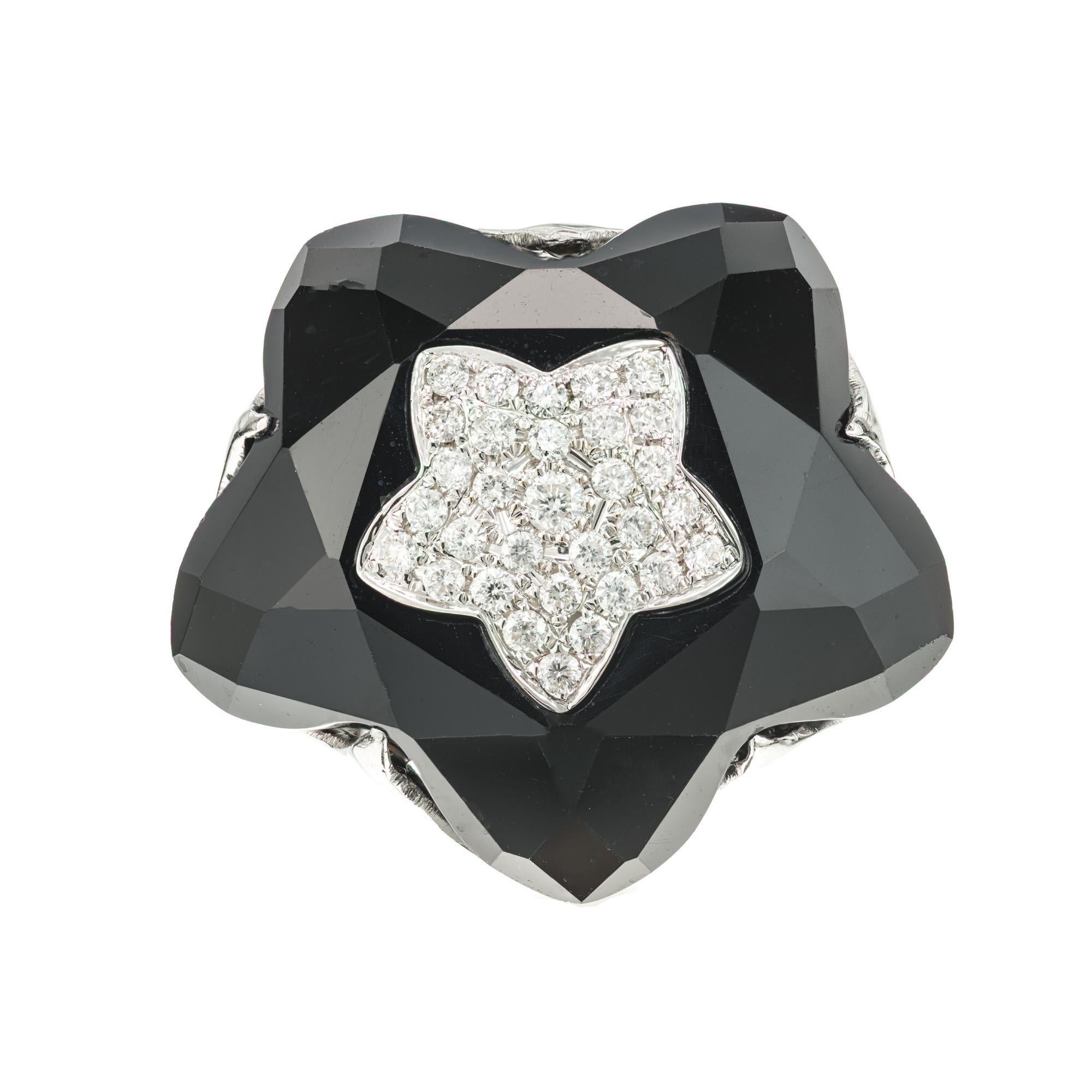 Black onyx and pave diamond star cluster cocktail ring. 81 round brilliant cut diamonds approximately .98cts set in a star cluster design with in a larger onyx star halo. 18k white gold. circa 2000

81 round brilliant cut diamonds, G-H VS SI approx.