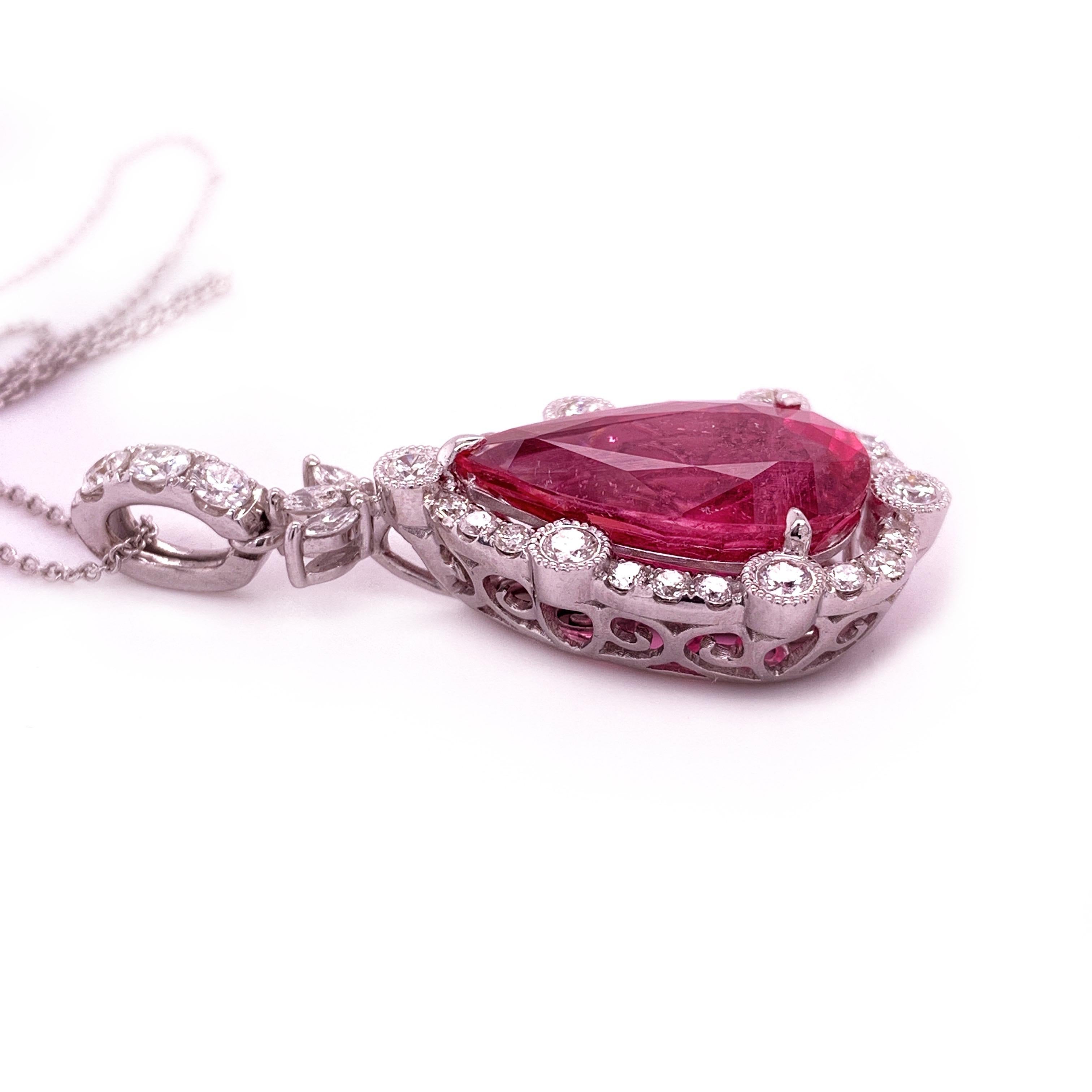 Elegant rubellite diamond pendant. High brilliance, pear faceted pinkish-red rubellite (tourmaline) encased in high profile with three knife prongs, framed with round brilliant cut diamonds. Handcrafted contemporary design set in 18 karats white