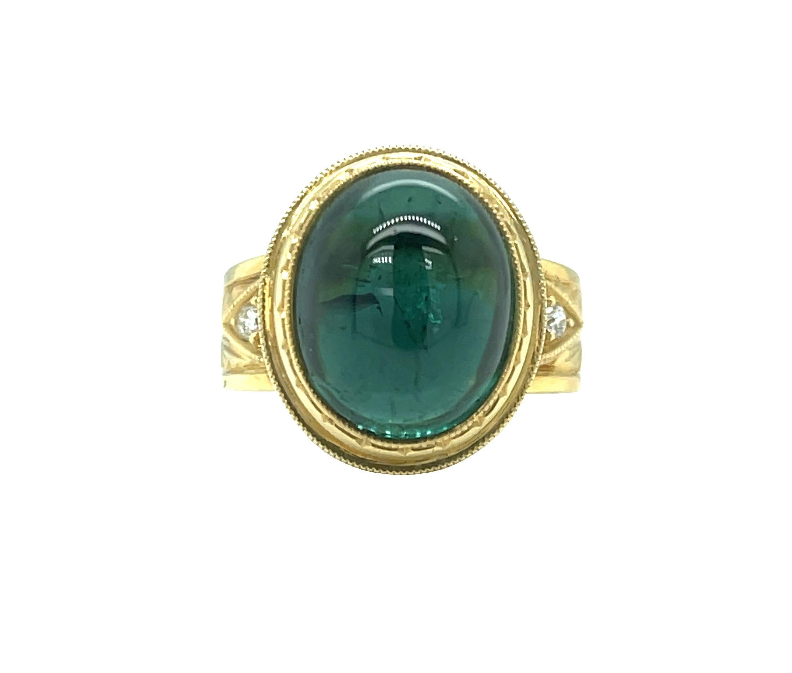 This exquisite, regal-looking dome ring features a fine, 9.80 carat oval green tourmaline cabochon set in a beautifully handmade, hand engraved bezel. The tourmaline has a rich, bluish green body color and has excellent clarity and transparency. The