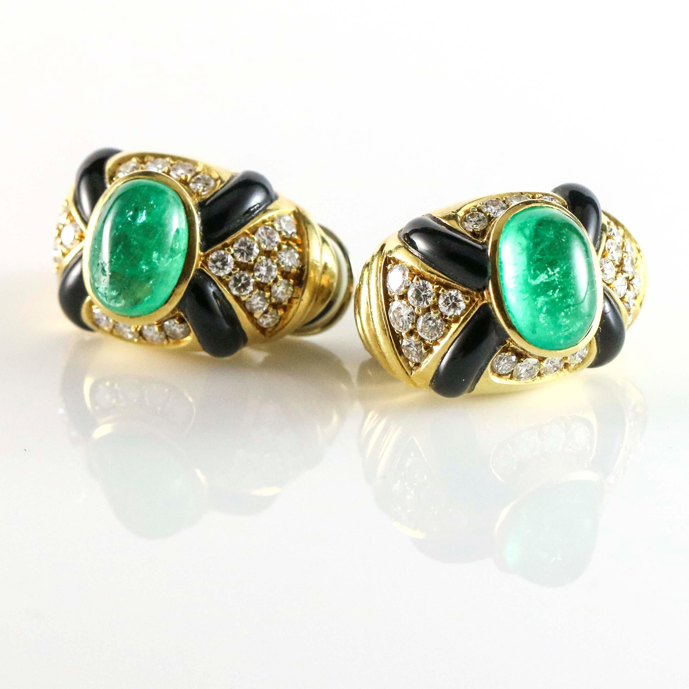 Vintage earclips with large cabochon emeralds, inlay black onyx and prong set with round diamonds. The earrings are crafted of 18 karat yellow gold. Clip-on backs. Estimated total carat weight of Emeralds, 7 carats. Diamond total carat weight, 2.8