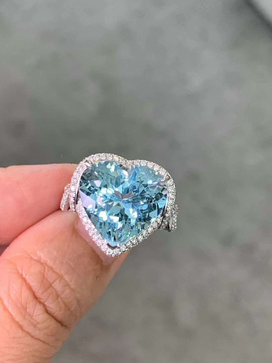 Squisito anello con acquamarina da 9,80 carati, evidenziata da 0,80 carati di diamanti scintillanti, incastonati in un lussuoso oro bianco 18 carati. La grande e radiosa gemma acquamarina, con il suo sereno colore blu, è al centro della scena,