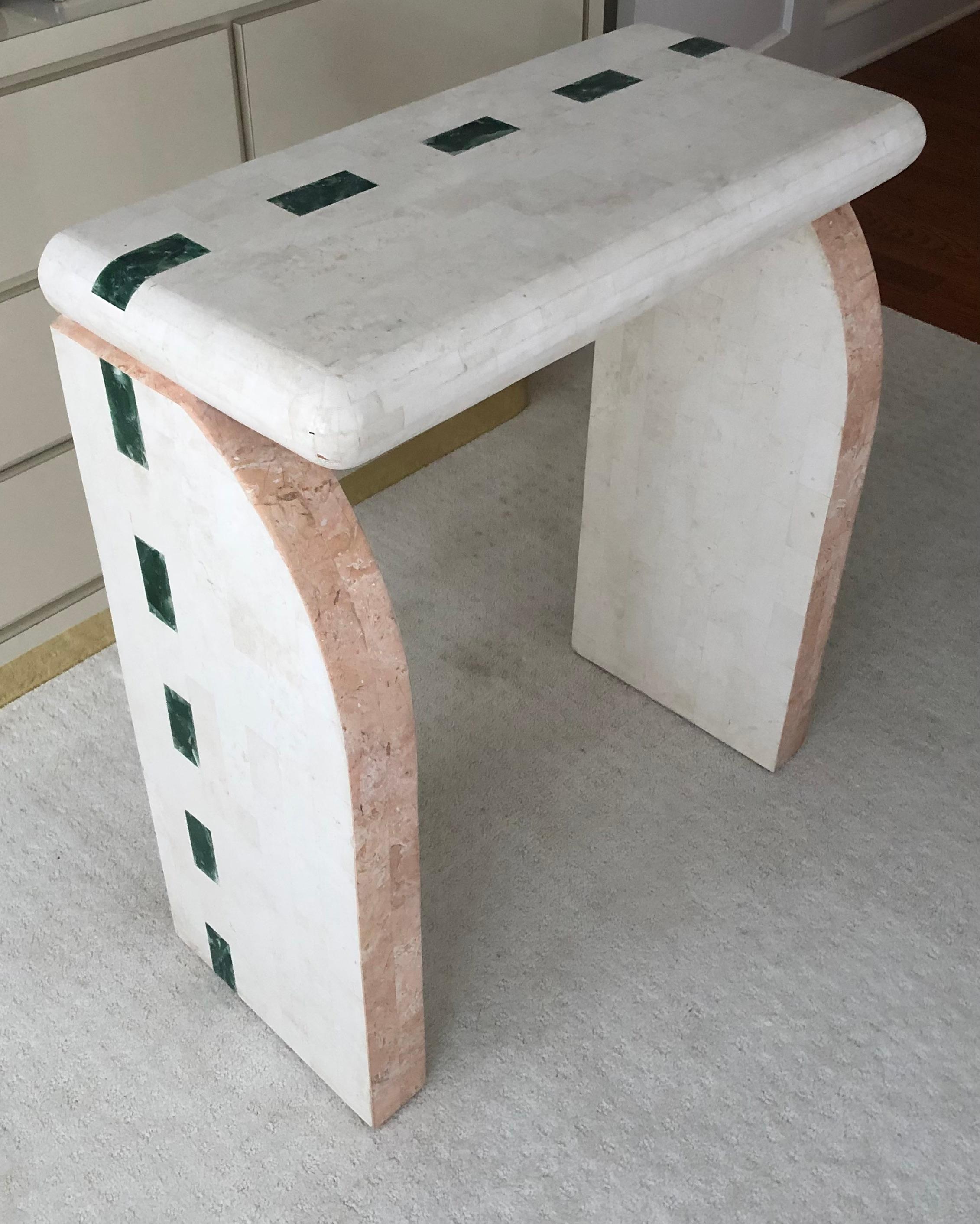 This is an interesting console table, with both Art Deco and Modernist lines. 

There is a tri-colore theme; Having a pink and cream tessellated fossil facade, and a repeating emerald-green inlaid geometric pattern . 
   
While no tags remain, I
