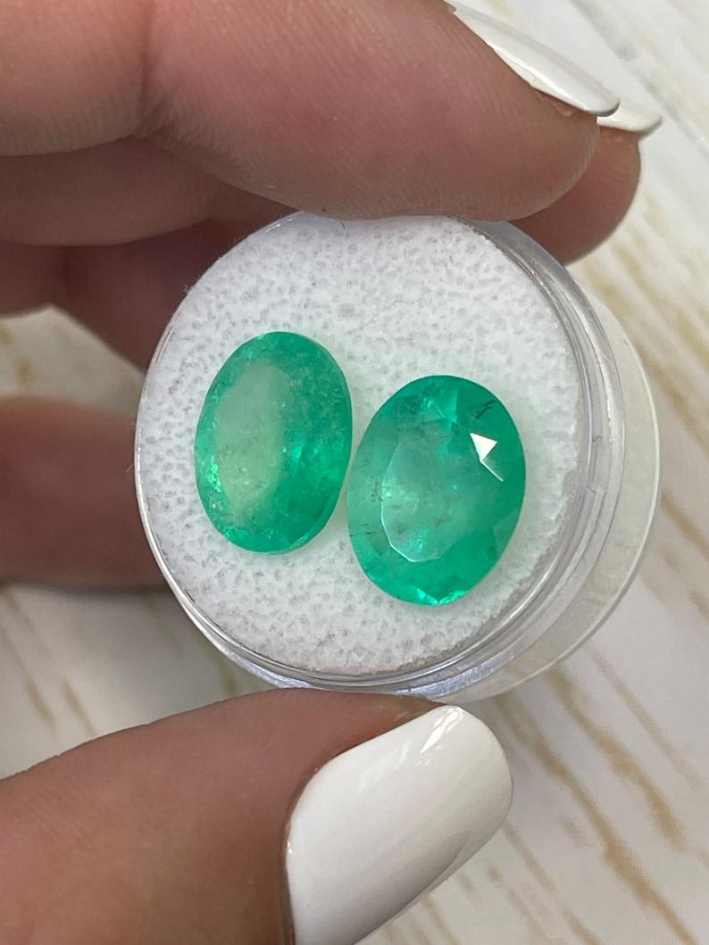 Pierre : Émeraude
Poids total : 9.81-tcw
Forme : Coupe ovale
Clarté : Transparent à Semi-Transparent
Lustre : Très bon
Couleur : Vert moyen
Dimensions : 12,82 mm x 9,92 mm x 6,20 mm // 12,76 mm x 9,93 mm x 7,64 mm
Origine géographique :
