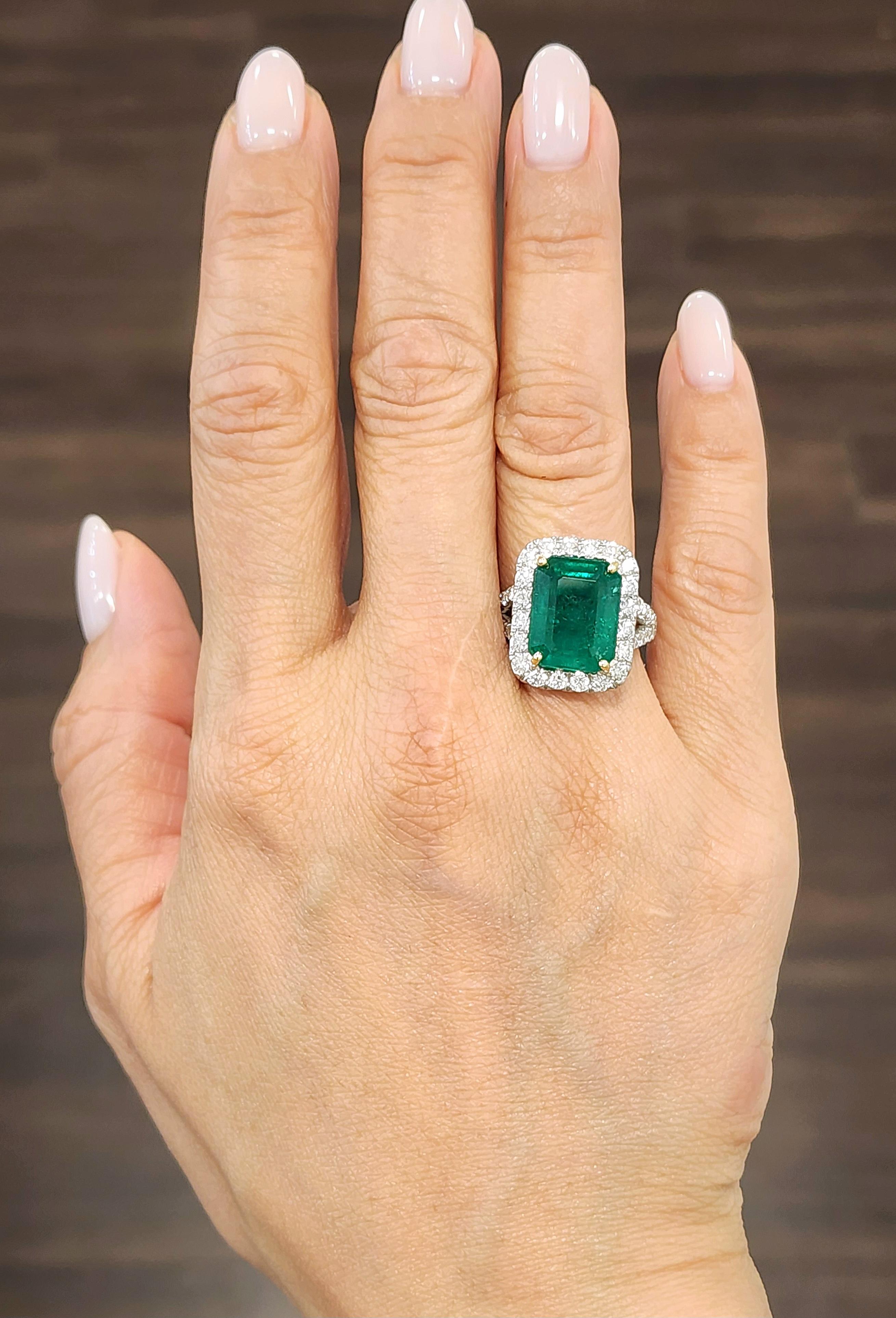Discover this stunning cocktail ring. The ring features an 8.20 ct GIA certified Zambian emerald-cut emerald with a rich green hue. It is elegantly surrounded by 47 round-cut white diamonds weighing 1.64 ct. The diamonds boast a VS2/SI1 clarity and