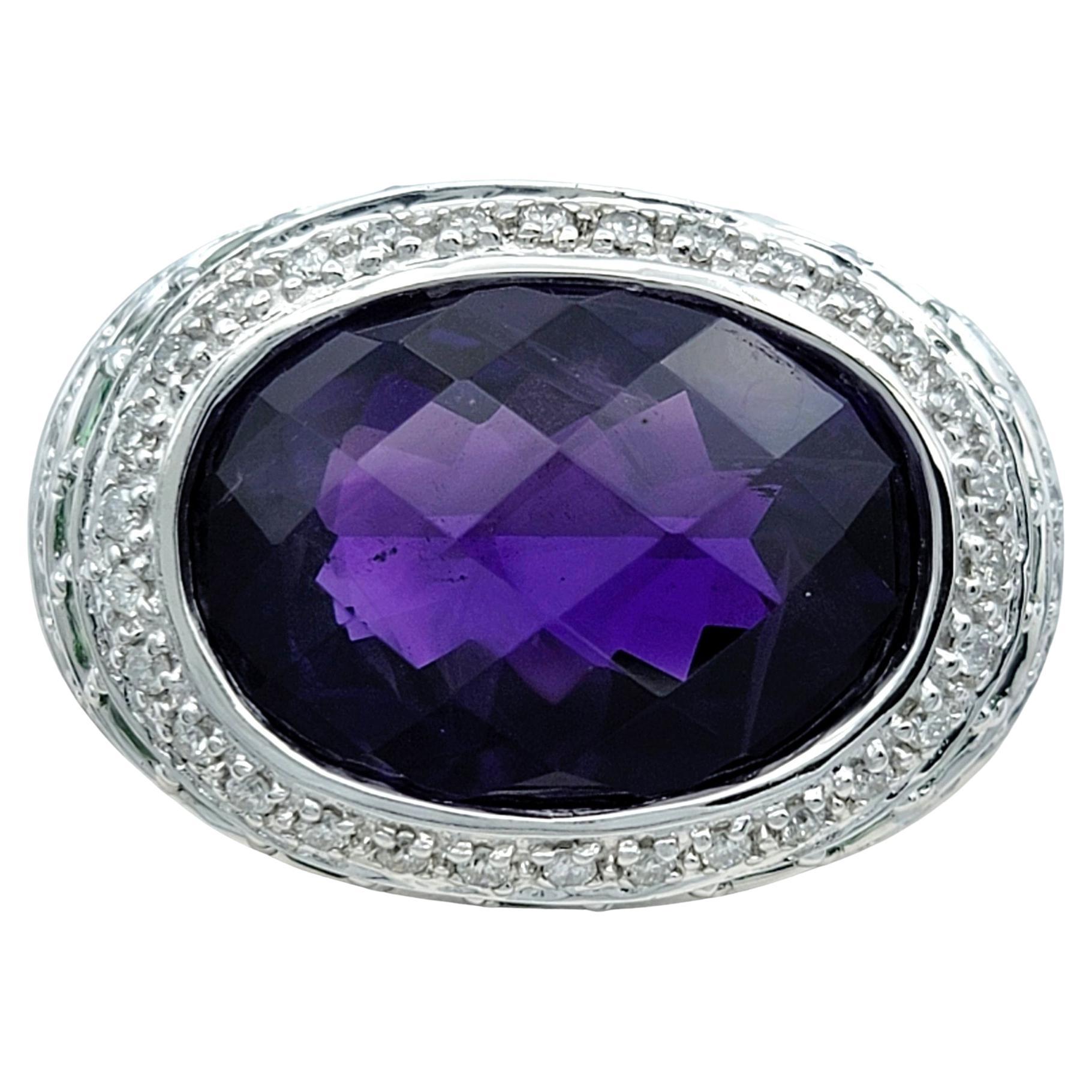 Ring Size: 7 3/4 

Elevate your style with this exquisite cocktail ring, featuring a captivating east-west set oval checkerboard cut amethyst as its centerpiece. The rich purple hue of the amethyst is beautifully showcased in a 14 karat white gold