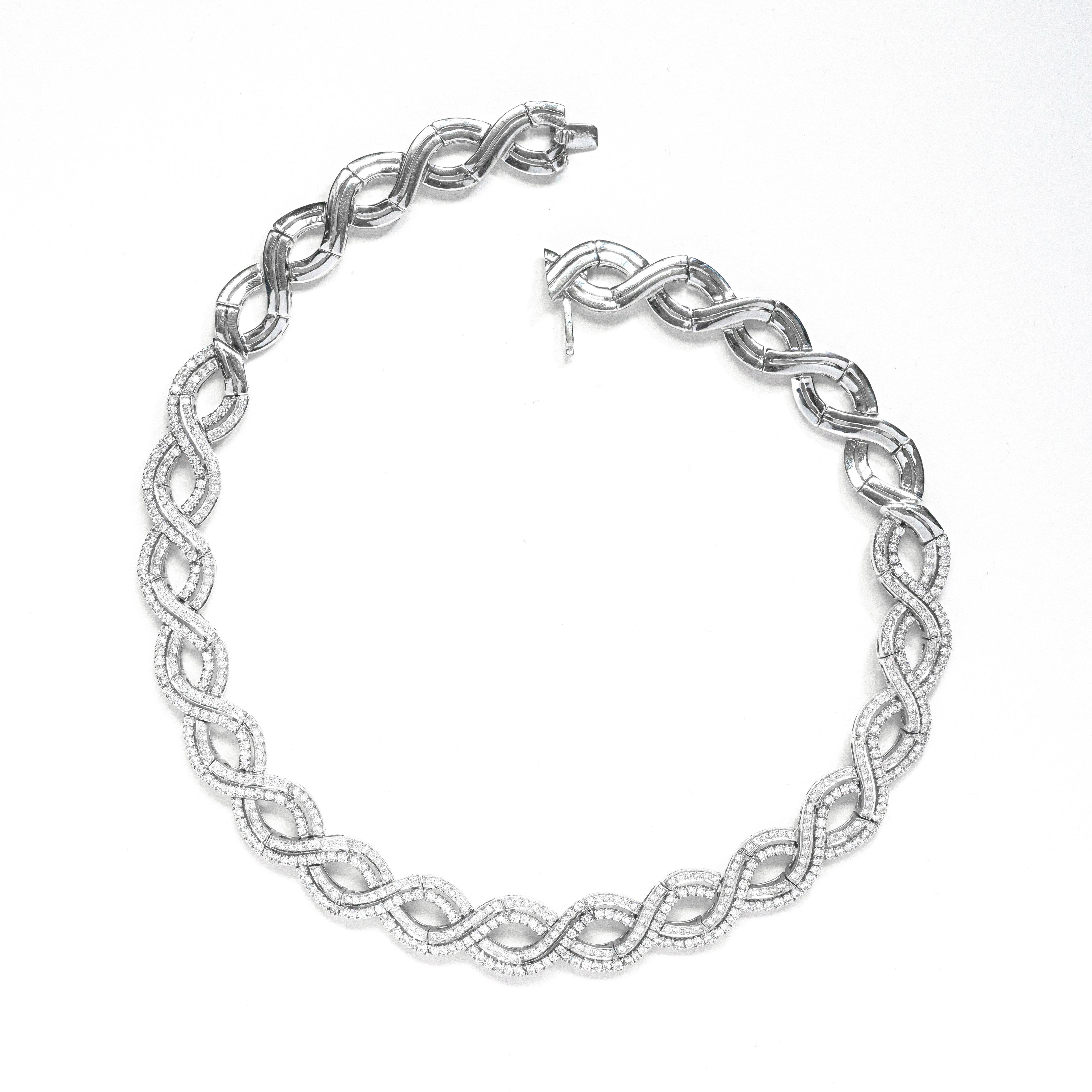 This stunning 18 carat white gold necklace features a flat twisted design enhanced by fine quality round brilliant cut diamonds shimmering throughout the frontal part of this mesmerising piece. The diamonds come to an impressive total weight of 9.88